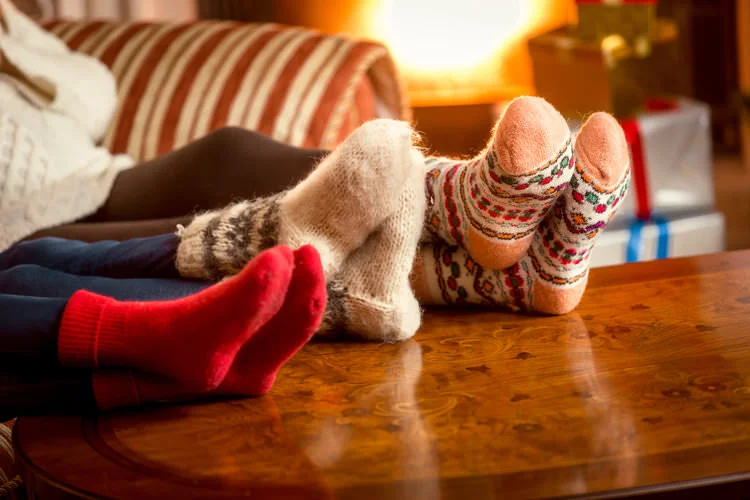 Closeup conceptual shot of family warming feet at fireplace in fuzzy socks.jpg
