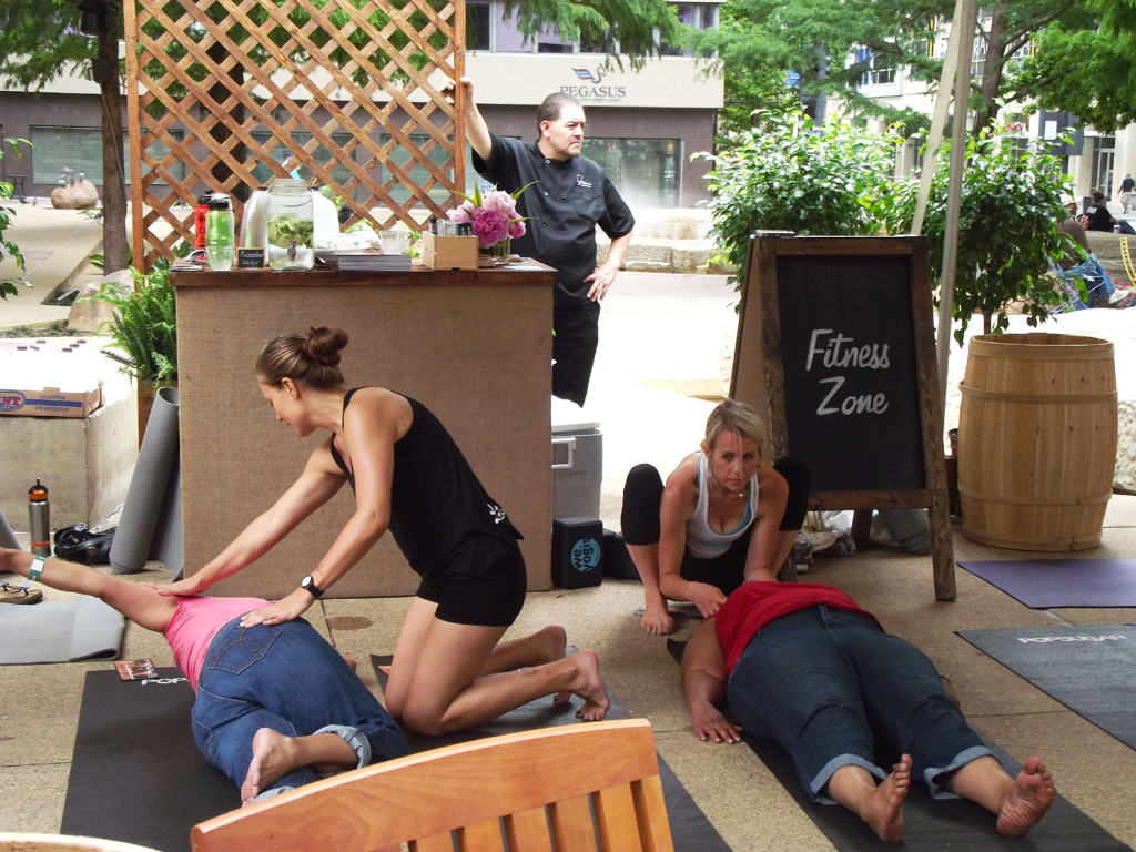 People exercising in the Fitness Zone with trainers.