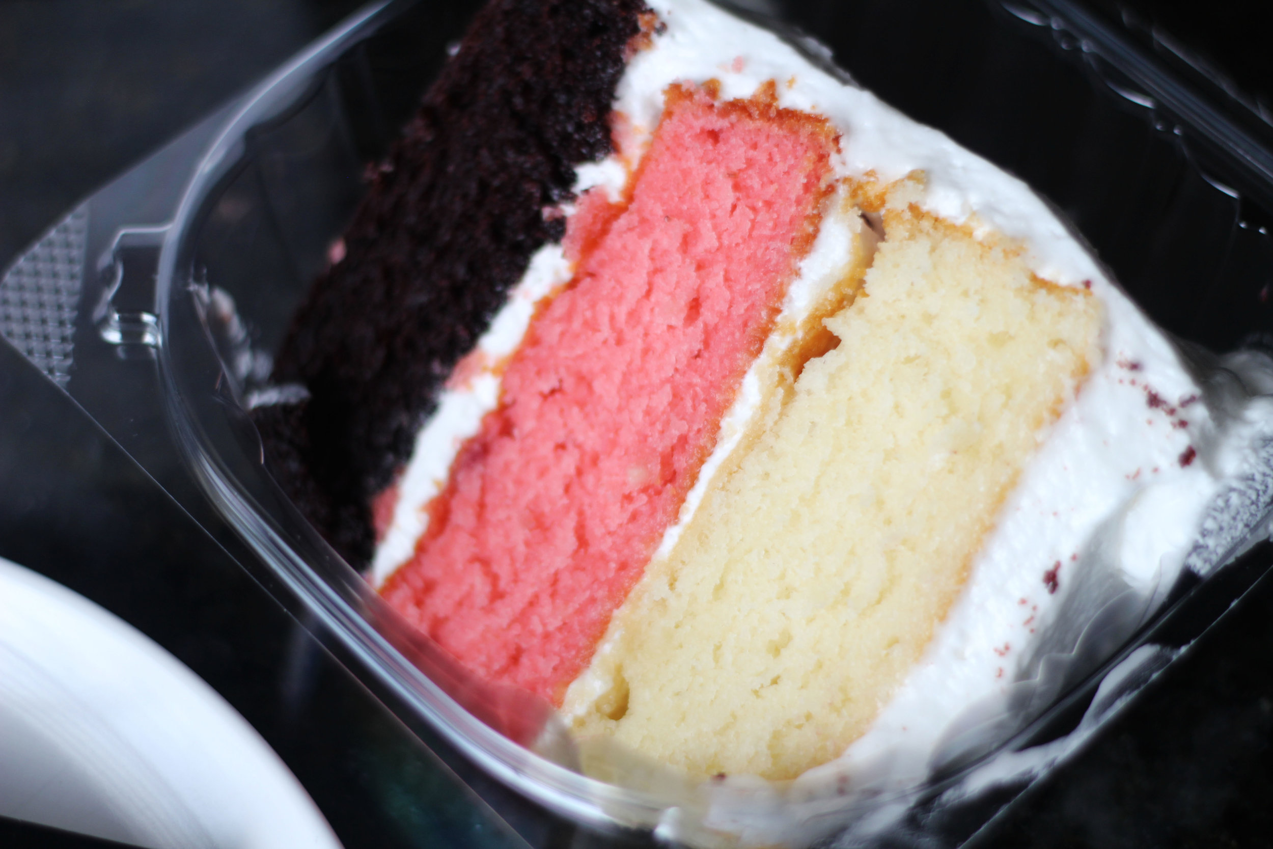 Slice of Neopolitan cake from Cake Bar at Trinity Groves (chocolate, strawberry, and vanilla layers).