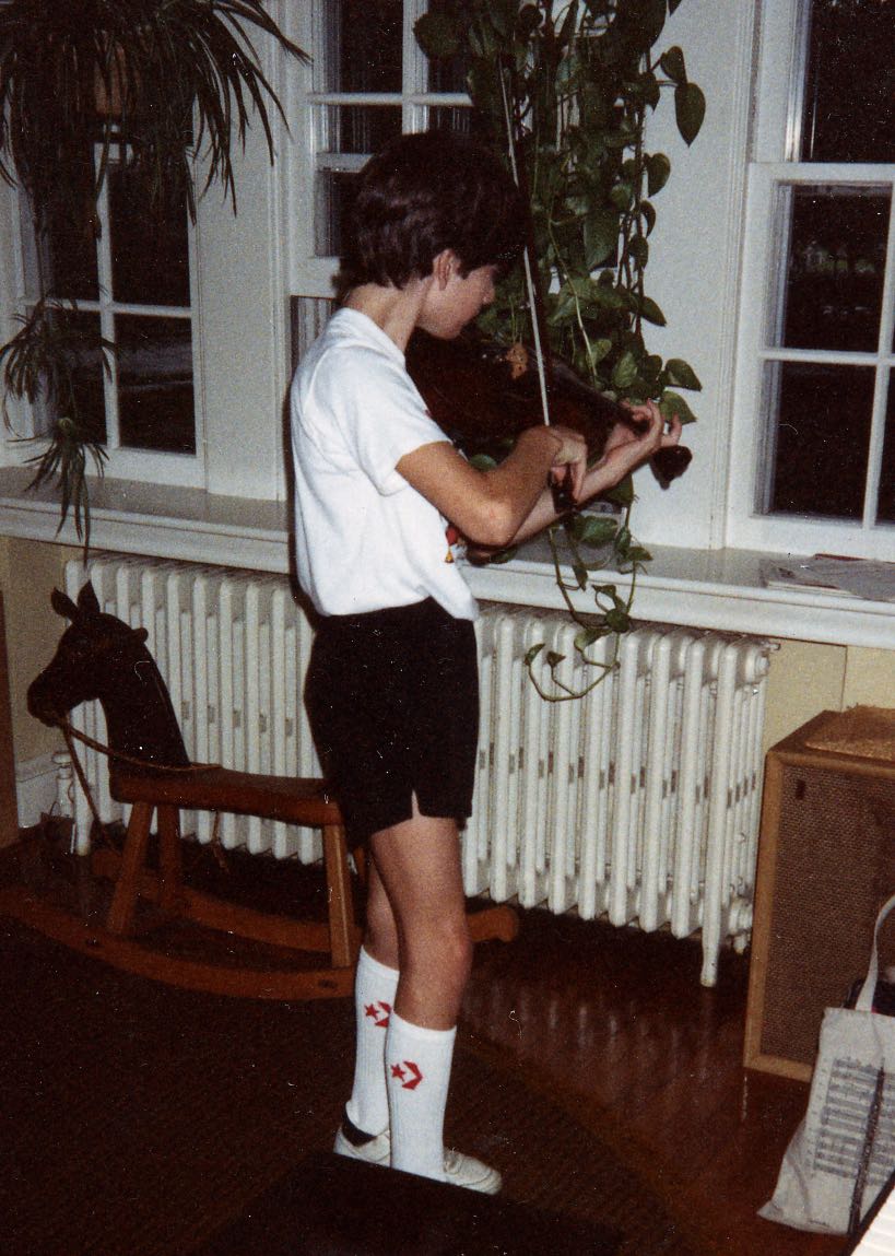 An awkward instrument made more awkward by how it’s held: a thirteen year old contorts his body to play the violin.