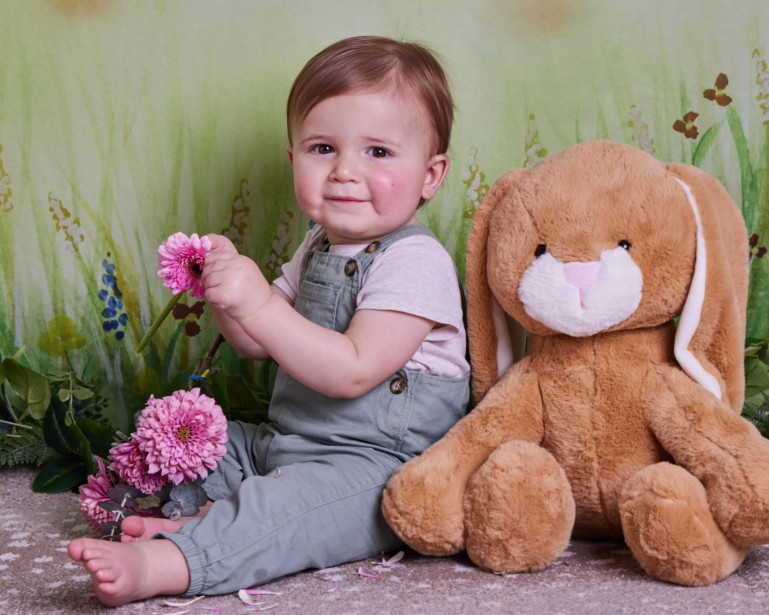 Toddler holding flowers posing with a bunny