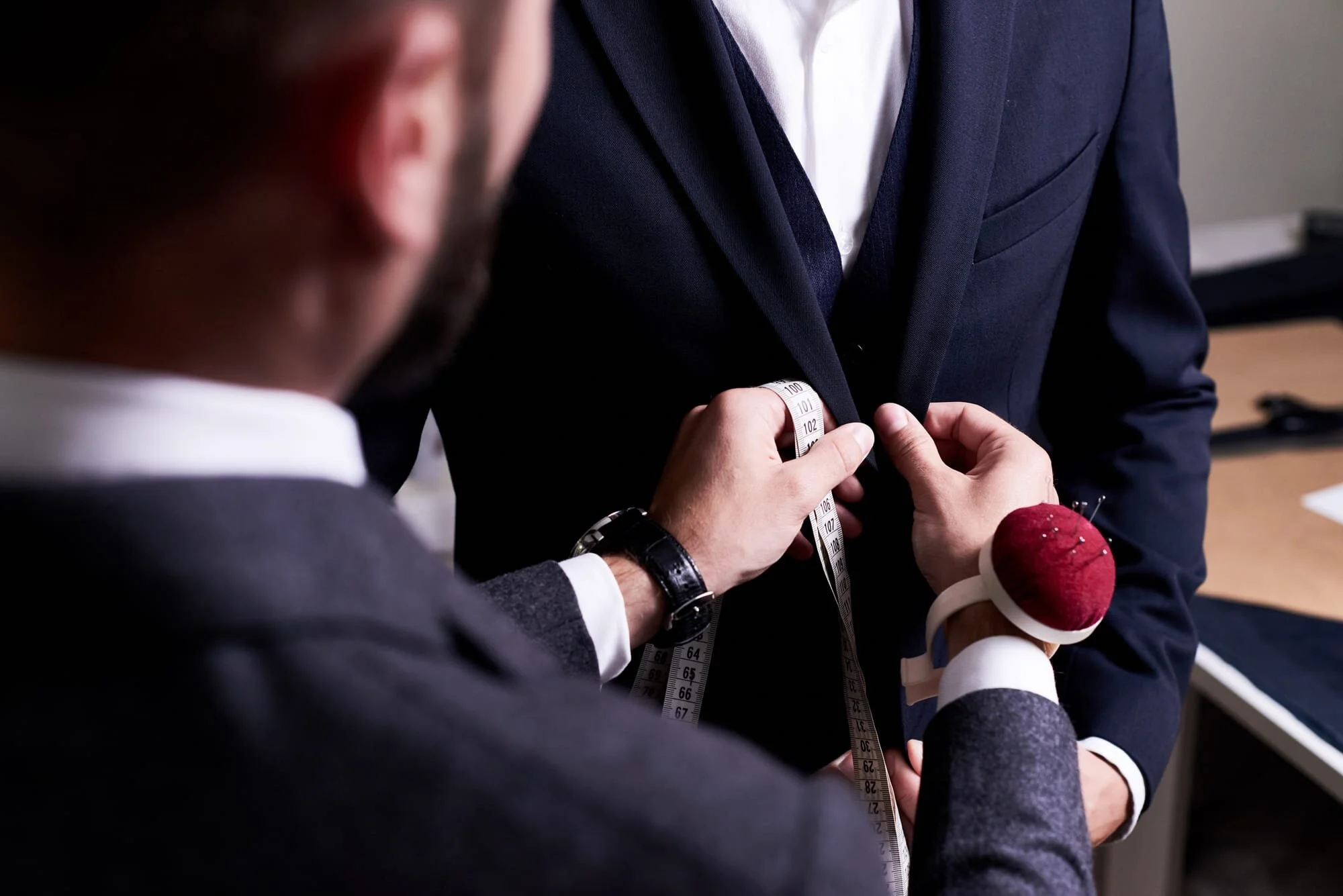 man-getting-his-suit-fitted-by-tailor.jpg
