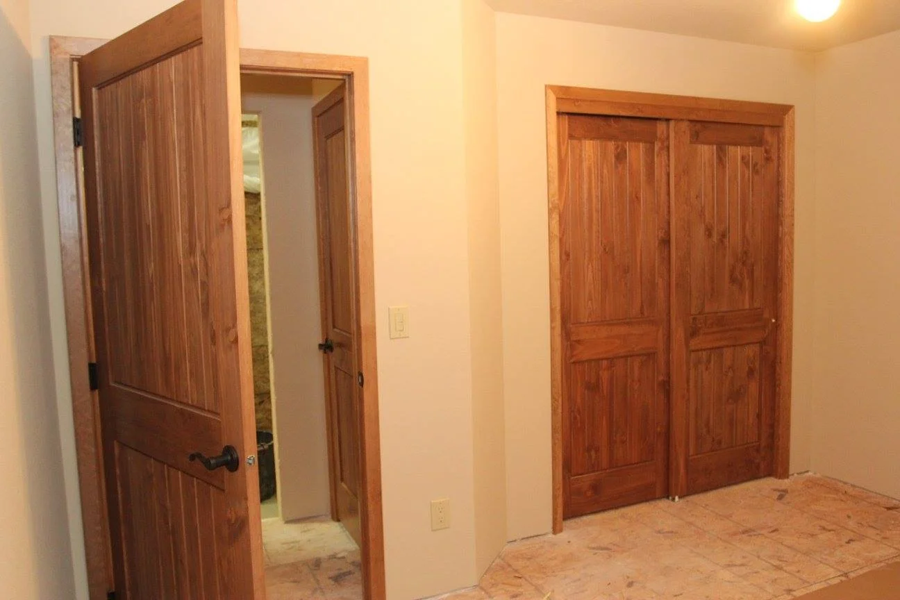 A week later in the build, a view of one of the bedrooms. Walls painted, doors installed.