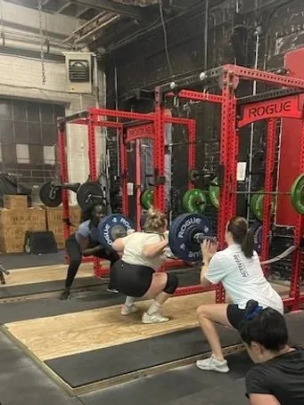 People lifting weights at Los Compenoes Gym.
