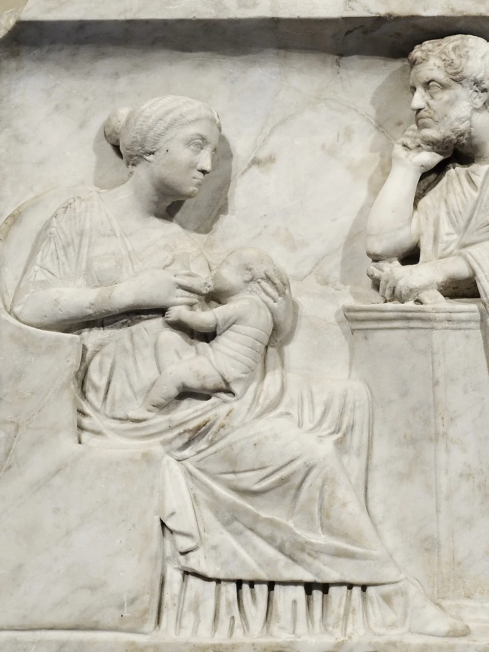 Detail of mother feeding child | Sarcophagus of Marcus Cornelius Statius, c.150CE, currently in the collection of the Louvre | Image Source
