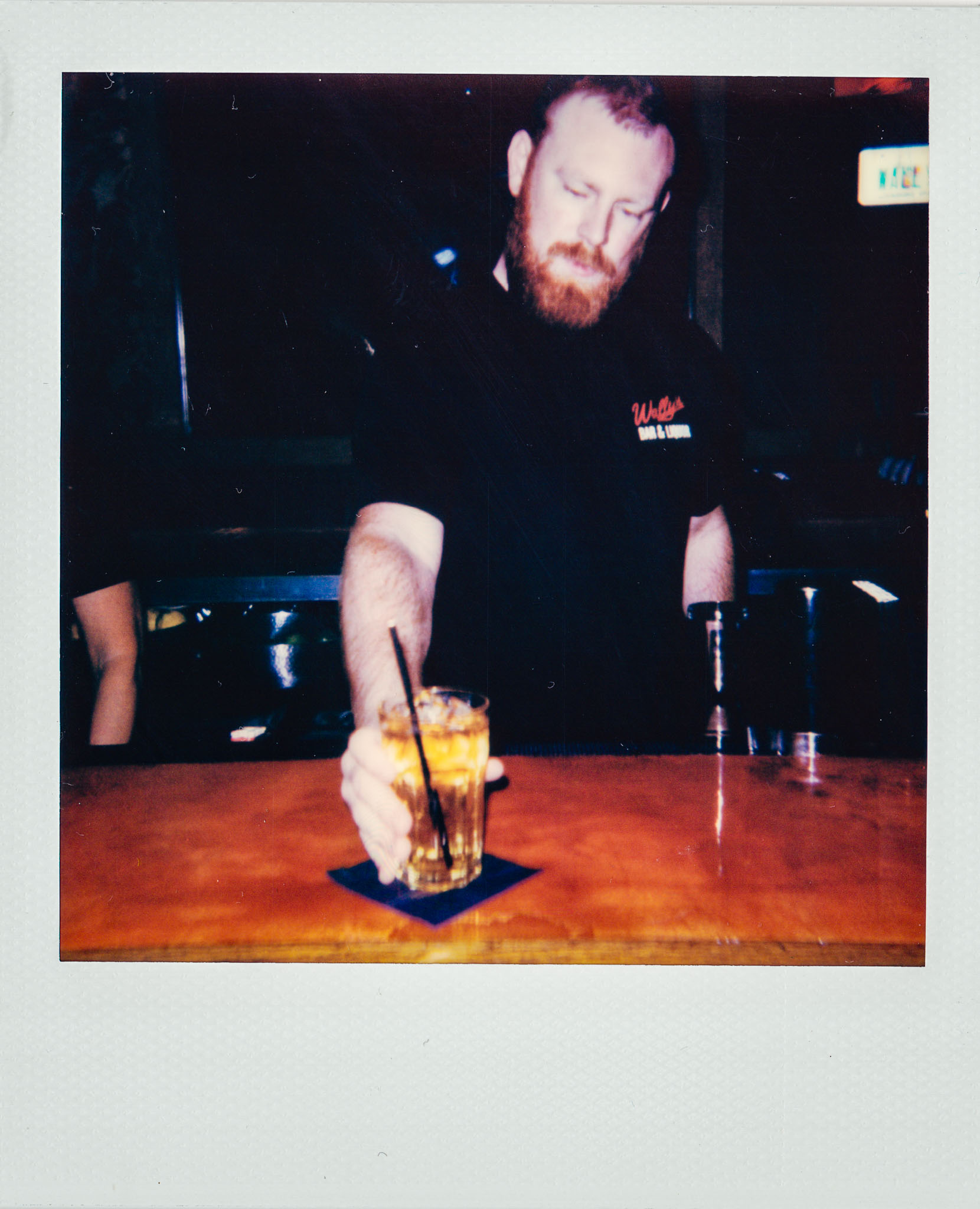 Redhead Bartender Serving a drink at Wallys Mills Avenue Liquors