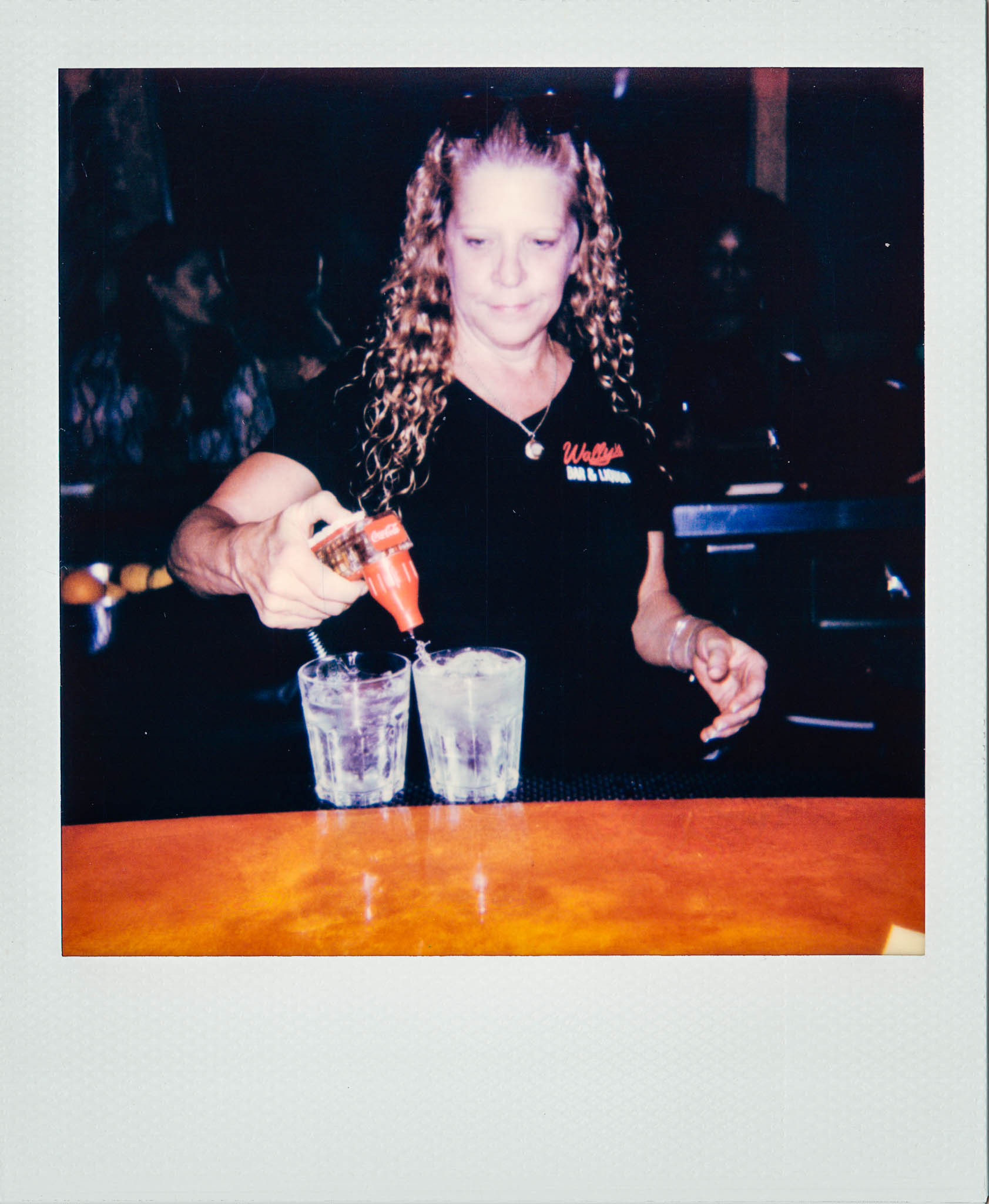 Female bartender making drinks at Wallys Mills Avenue Bar