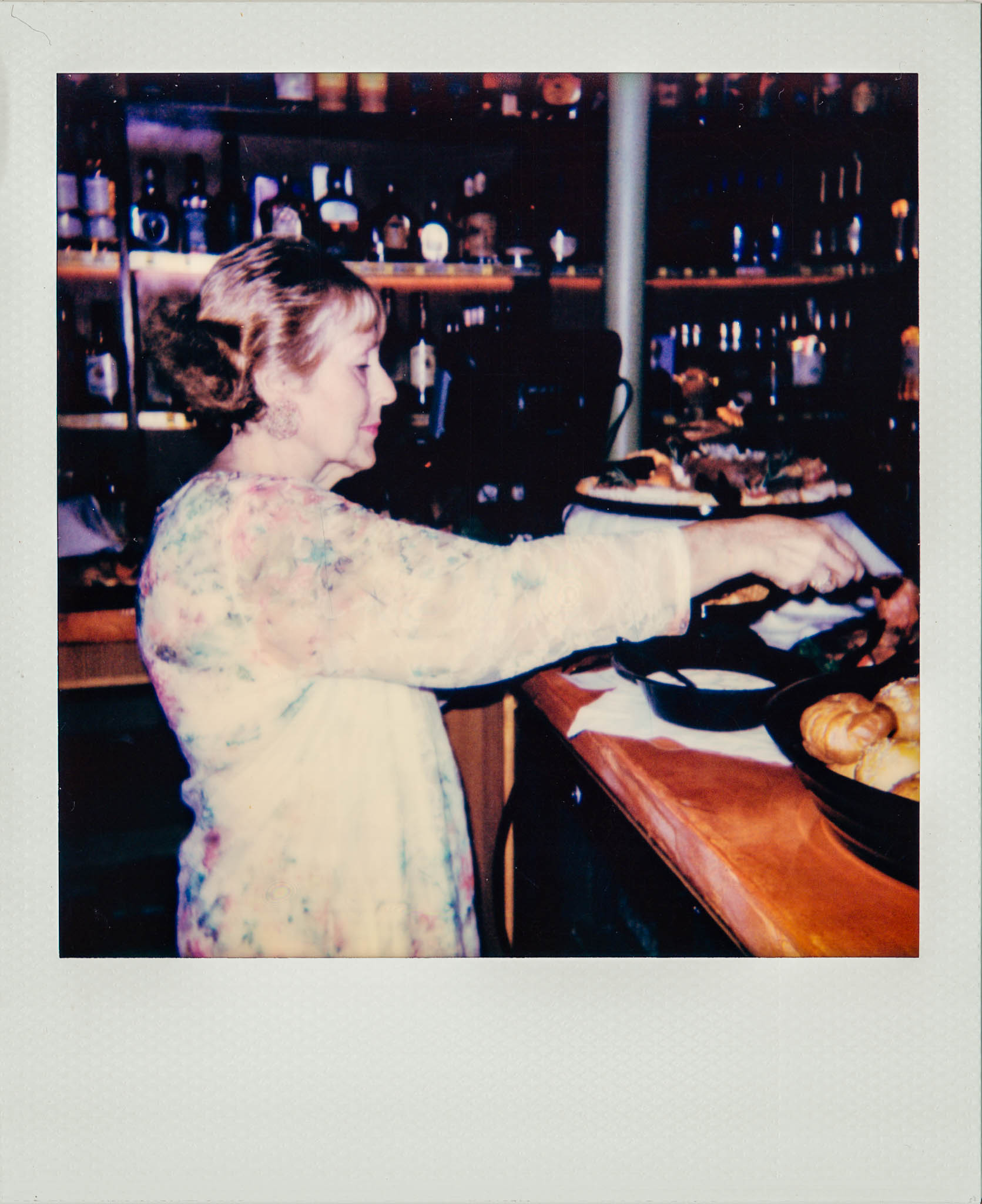 Linda Updike filling a plate with food at Wallys Mills Ave Liquors.