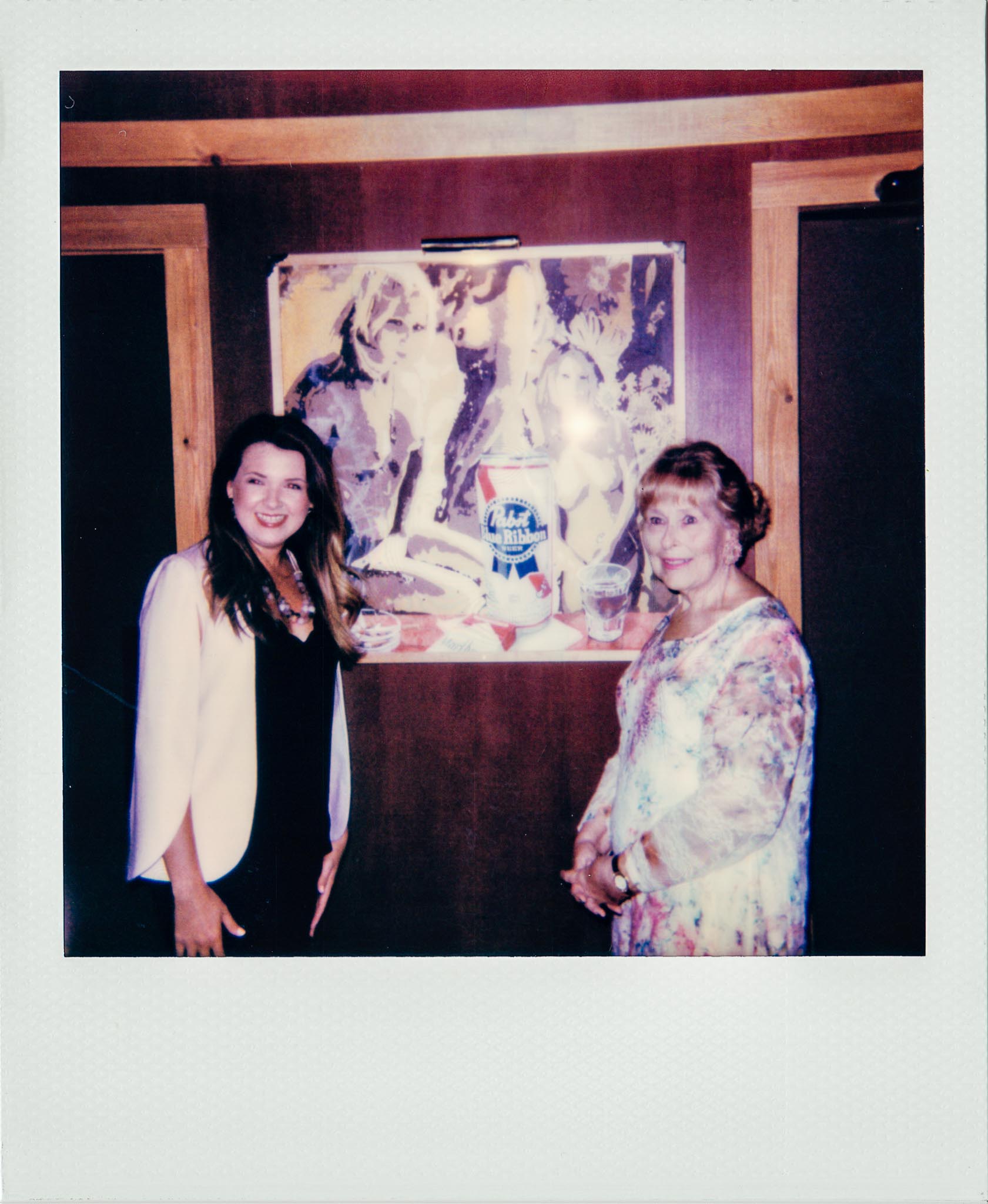 Linda Updike and Lauren Ferriola posing in front of Wallys Nude Wall paper 