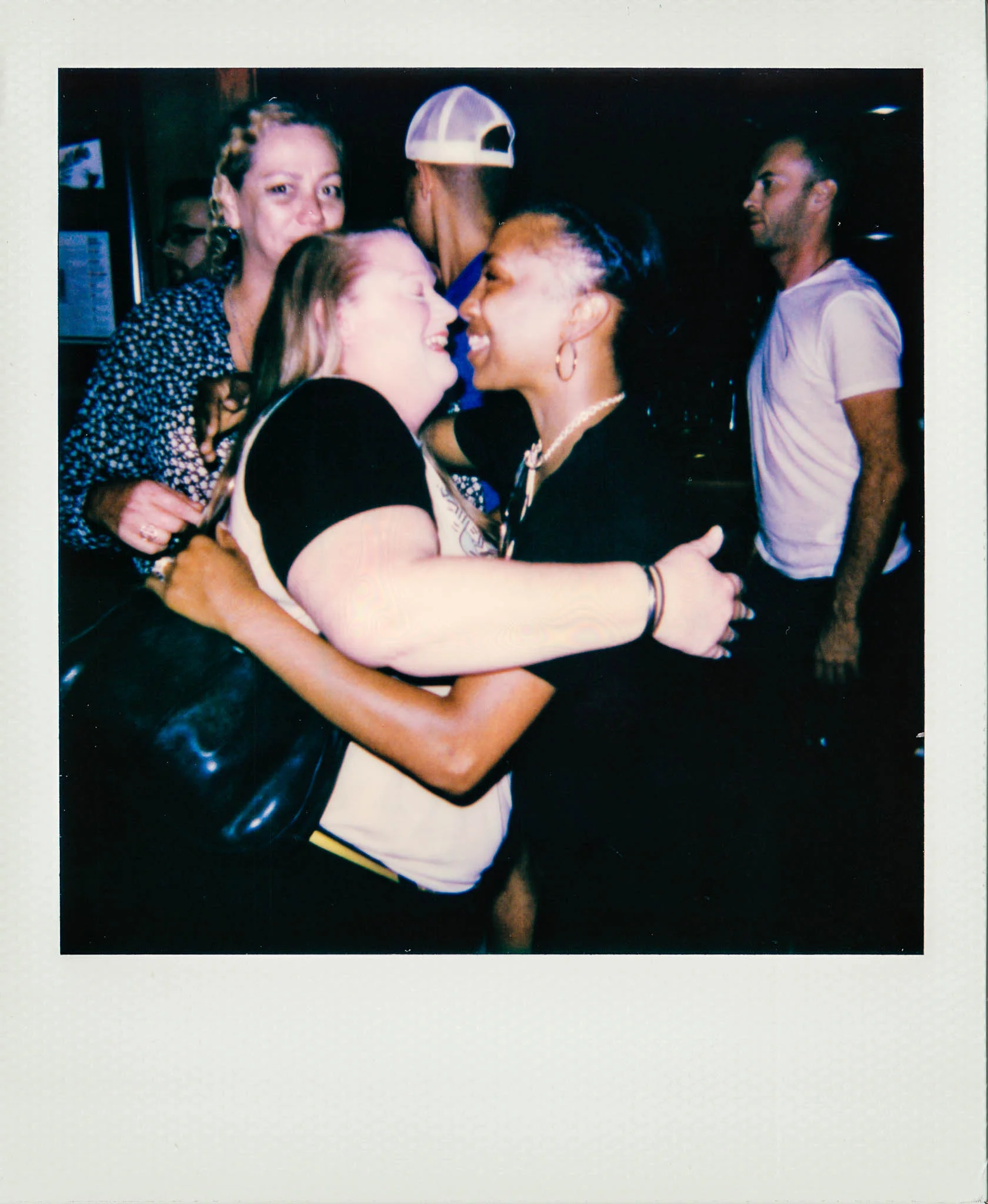 Bartender and customer hugging at Wallys Mills Avenue Liquors