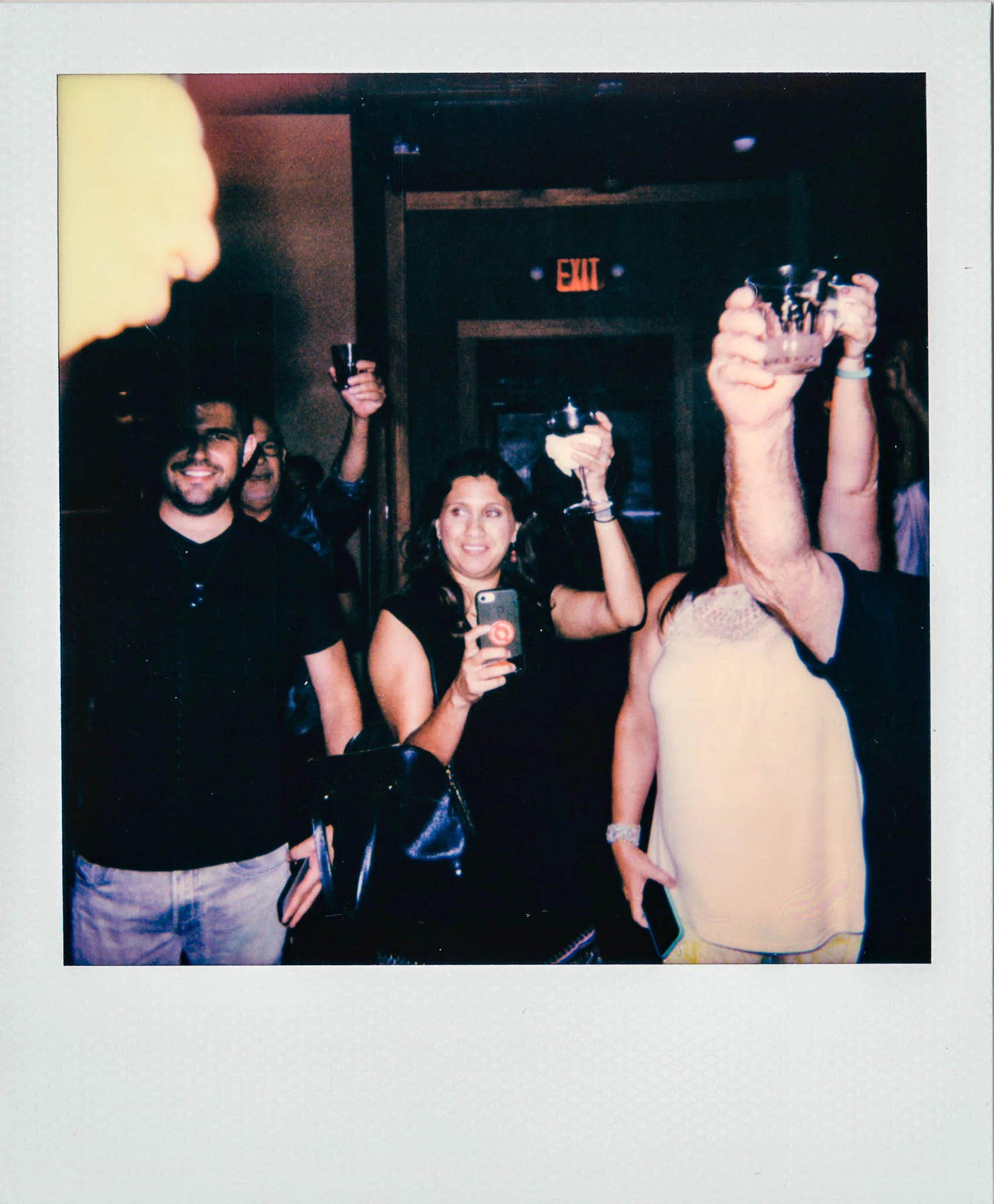 A group of people giving a toast at Wallys Mills Avenue Liquors