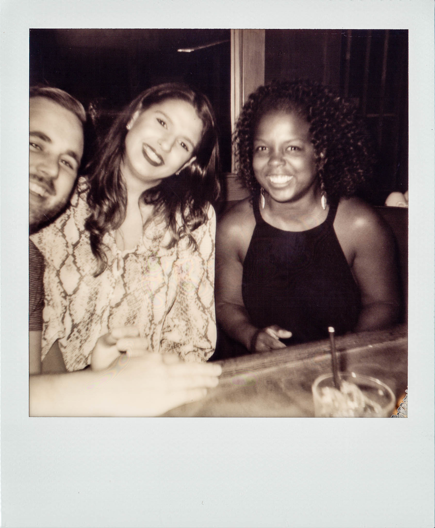 Two girls and one guy sitting together at Wallys Mills Avenue Liquors