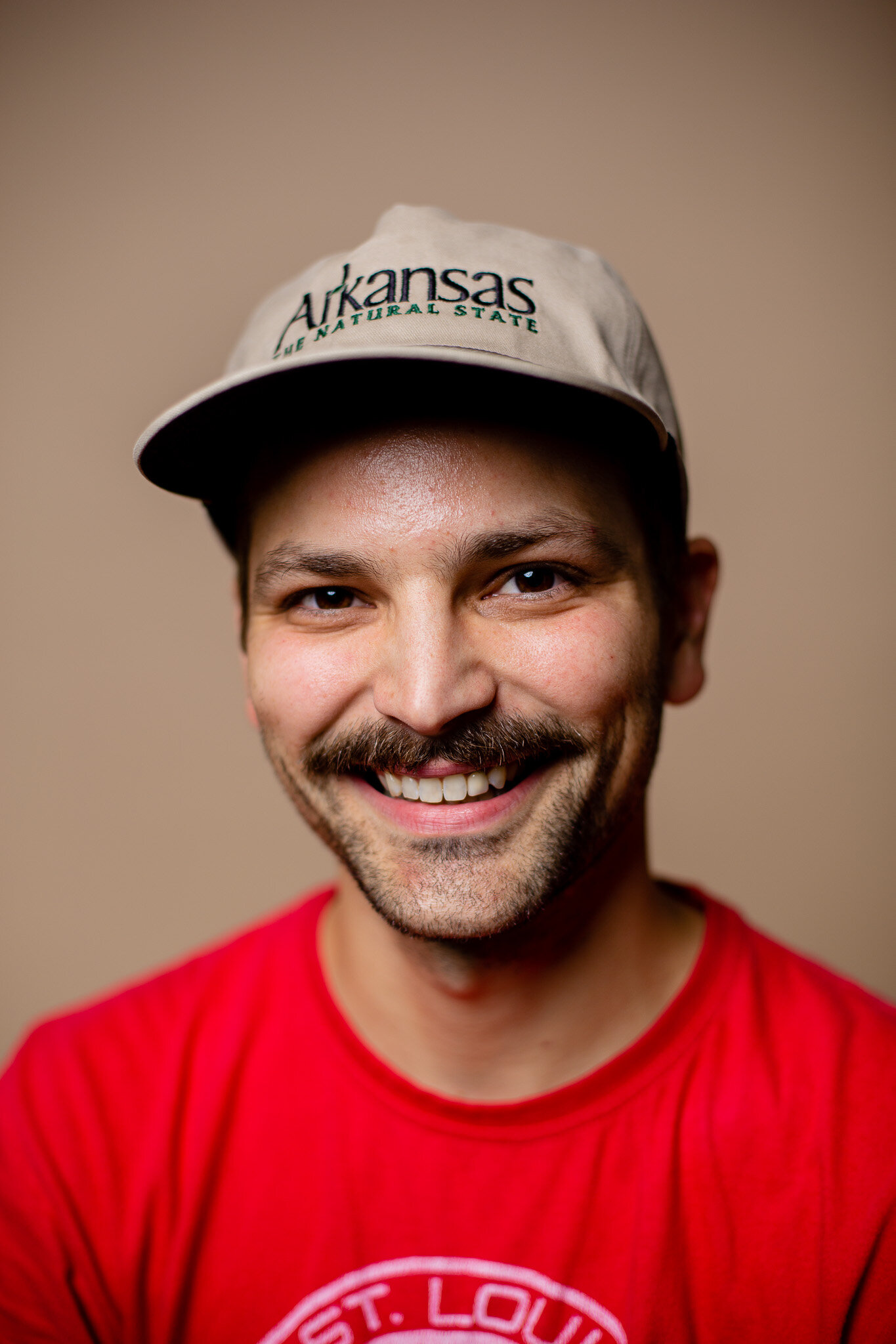 Tyler from Whippoorwill smiling and wearing an Arkansas hat