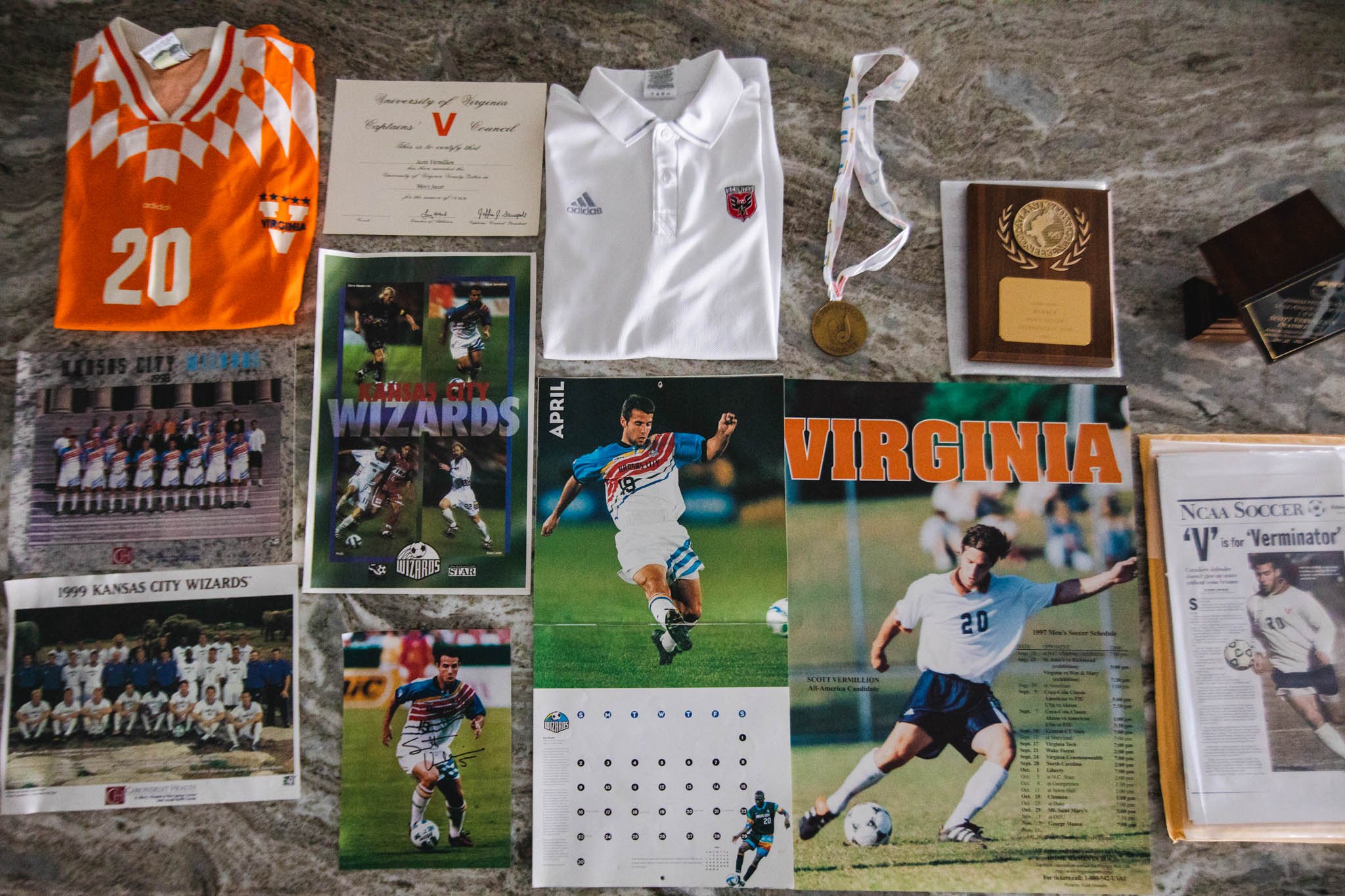 Collection of Virginia Cavaliers soccer memorabilia, including photographs, a medal, a jersey, and a printed schedule.