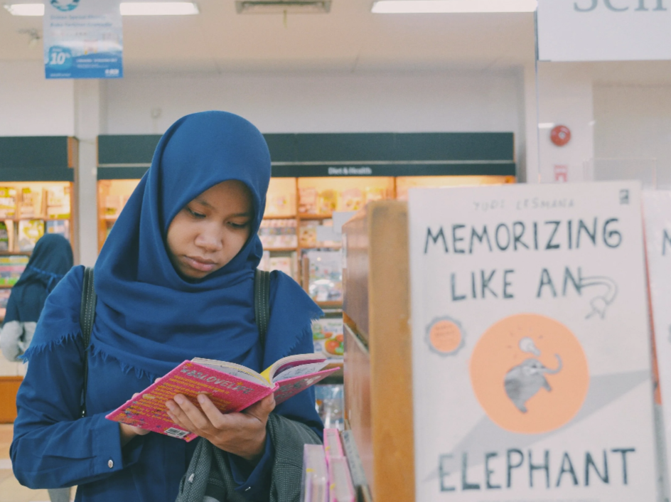 woman reading book in store.png