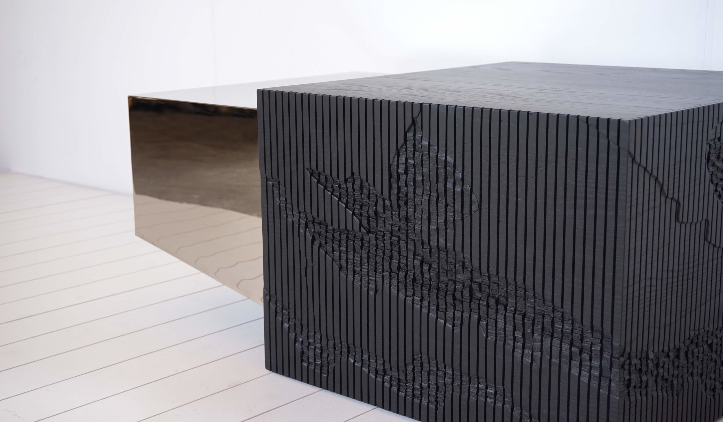 The Shale Collection consists of a credenza and a coffee table, made with solid Ash wood and mirror or chrome plated steel. The particularity of these pieces lies within the textures, one reminiscent of stone, hand carved in solid ash, and the other cool and crisp, either mirror or chrome, for the credenza and table respectively. The Shale Collection's name was inspired by the cliffs outside Simon Johns' studio, in the Missisquoi Valley in Quebec. Shale is a type of rock formation that tends to split and erode in layers, leaving behind a layered and random composition of textures. The mapping of the composition of this cliff was sketched on to the two pieces of the collection, and carved out in layers, with a router and a chisel.