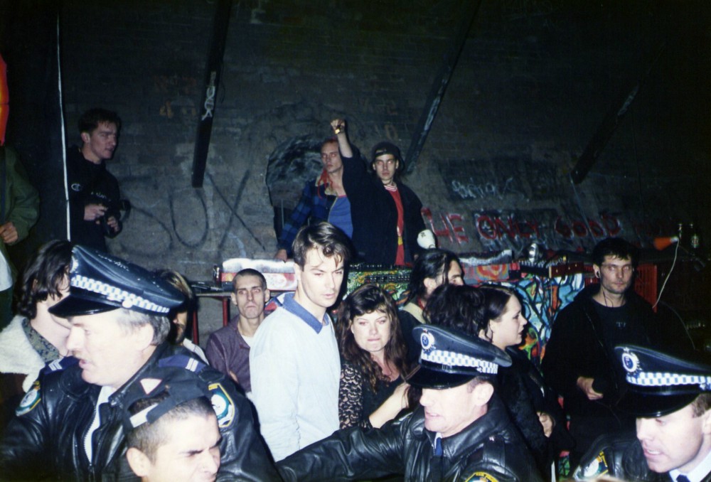 A 1995 rave in Australia being broken up by police. Recreational MDMA use spread globally with rave party culture. (Wikimedia)