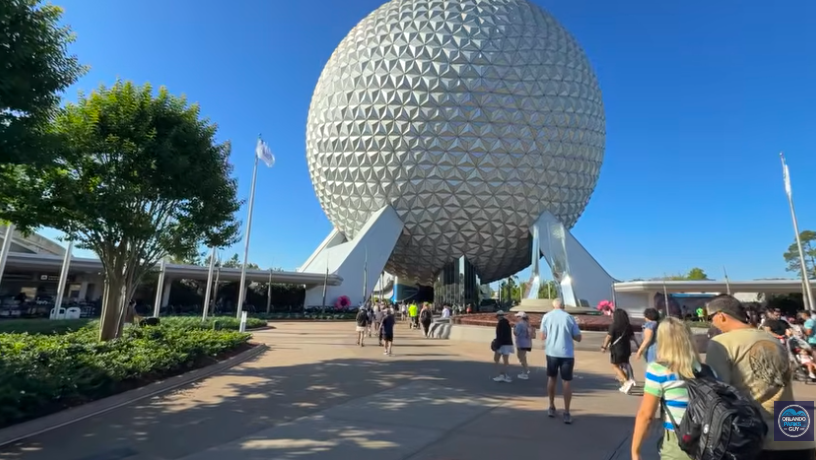 people walking into Epcot heading towards Spaceship Earth