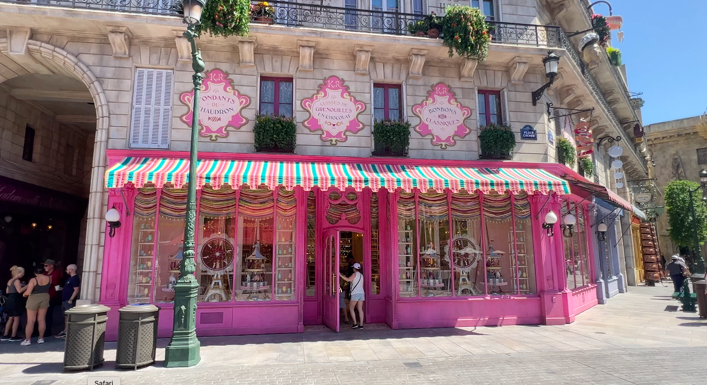 Candy shop inside Harry Potter at Epic Universe. The store is bright pink with whimsical displays in the windows.