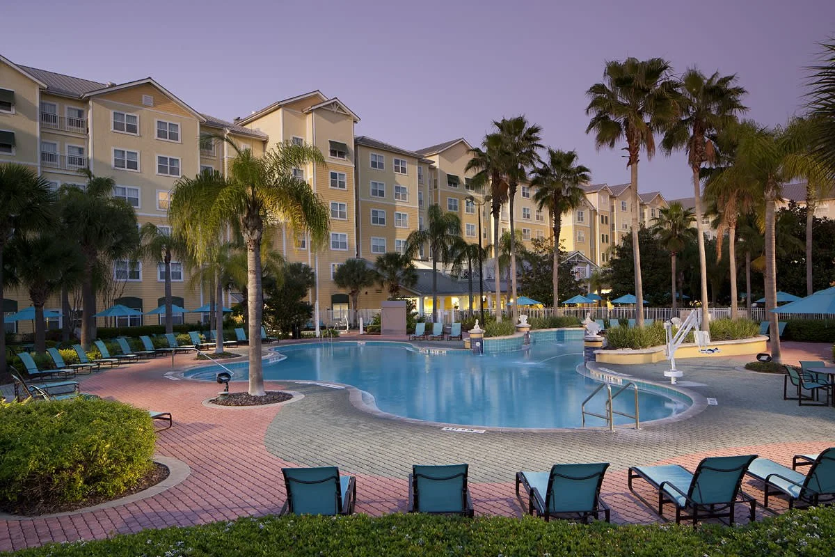 The pool at residence inn orlando seaworld at dusk with the hotel in the background