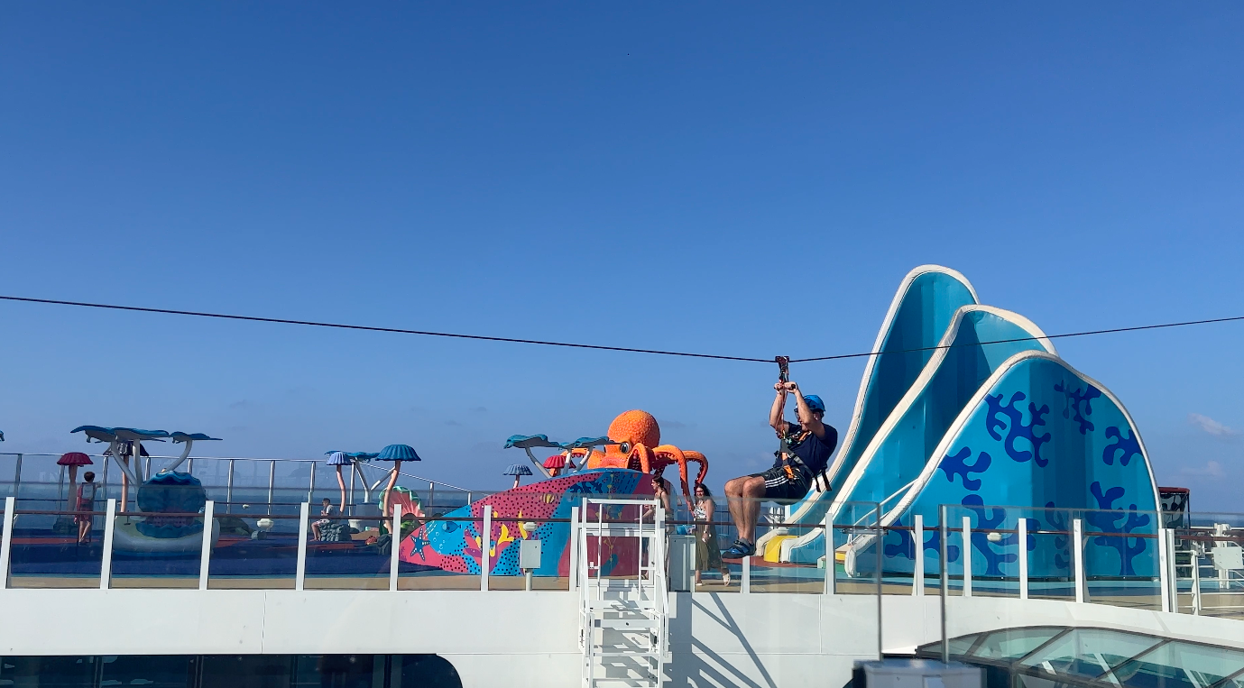 Me on a zip line going across the top deck on Wonder of the Seas