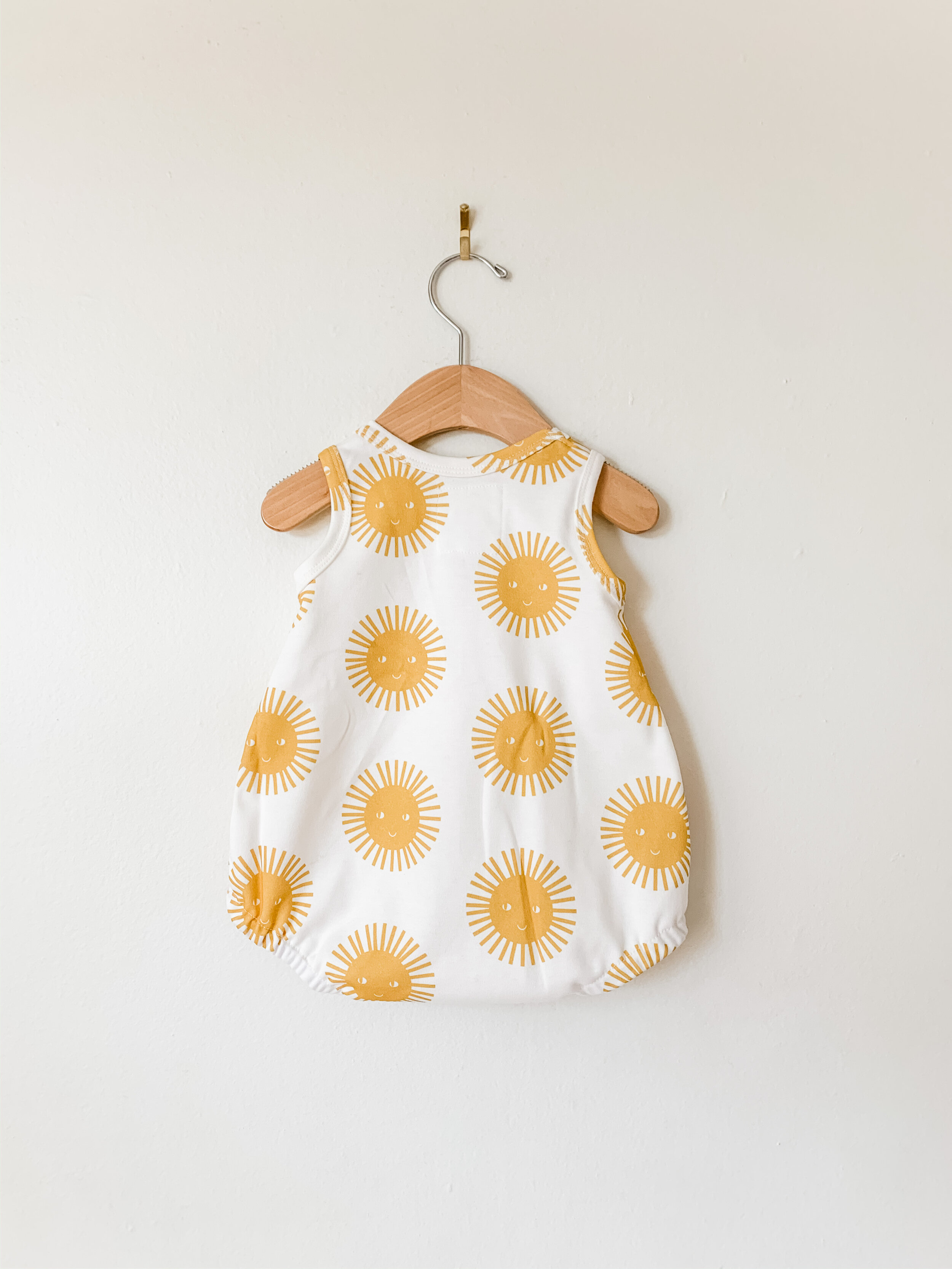 baby bubble romper with white background and yellow smiling sunshines