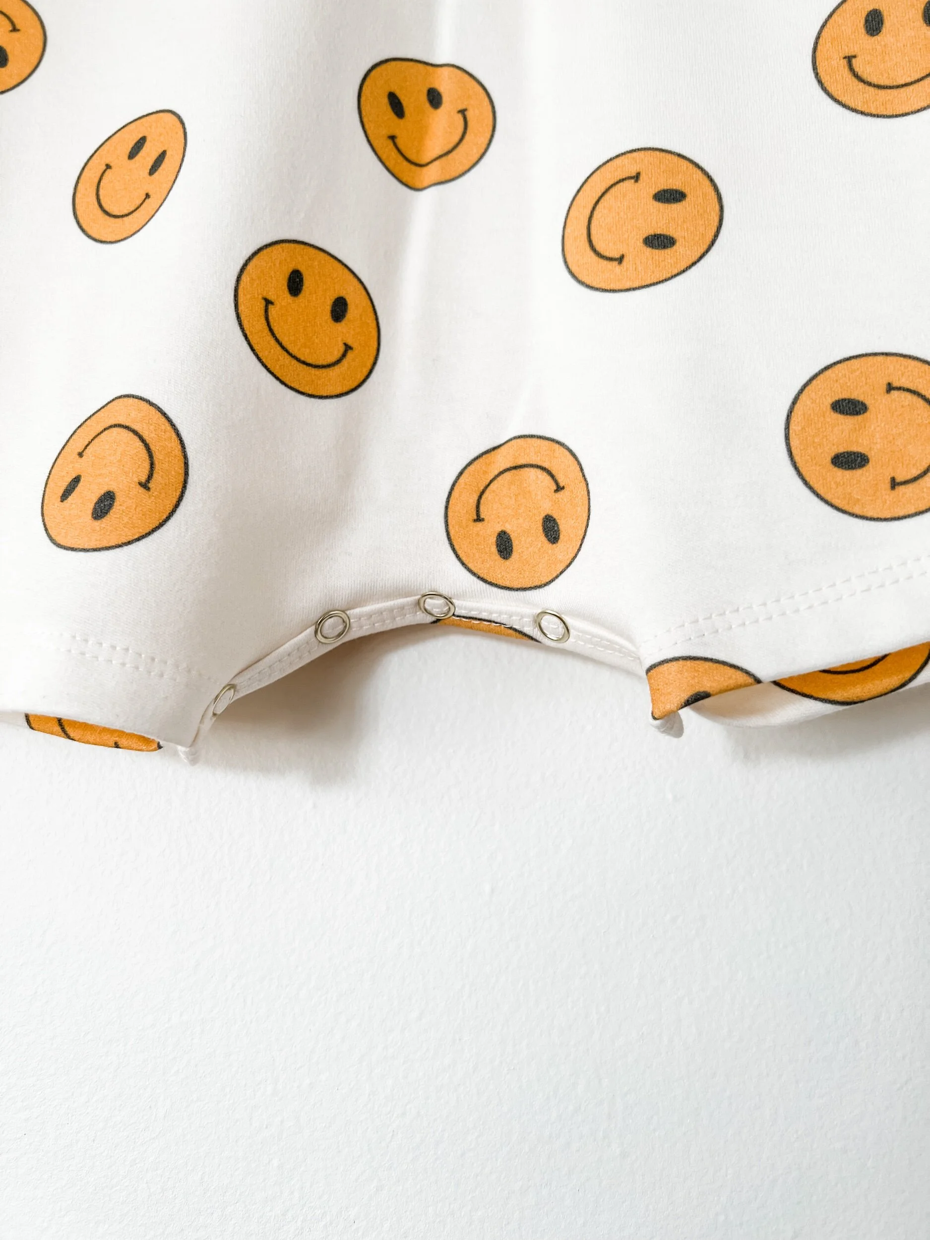 baby romper in white with yellow smiley face
