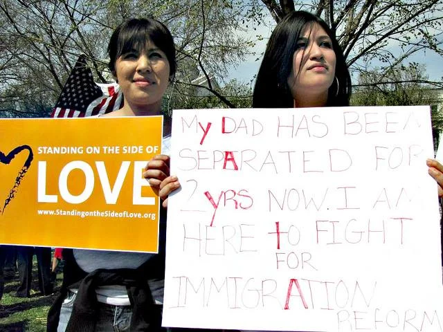 Two supporters hold SSL signs at an immigration justice march in 2011.