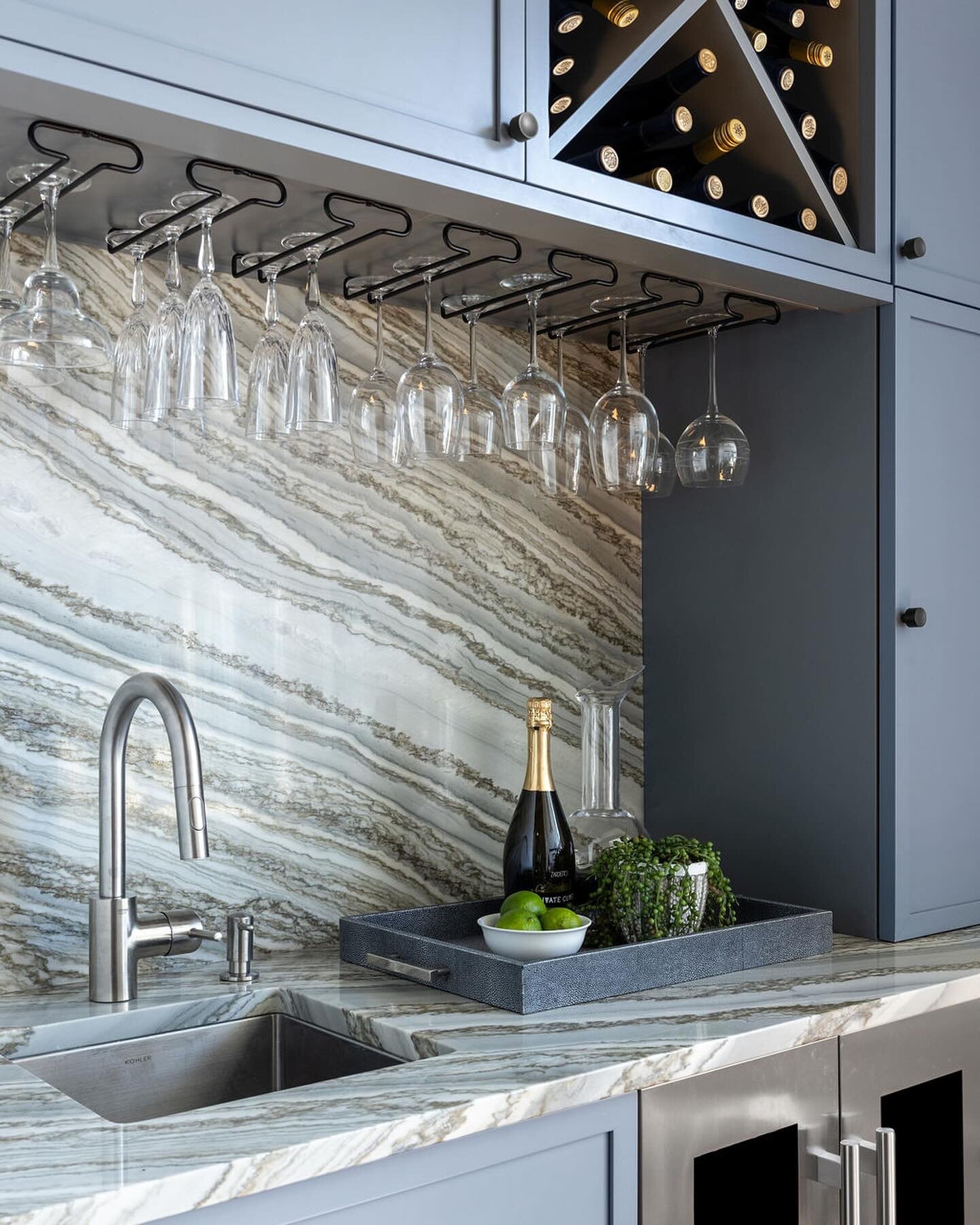 The full height marble backsplash is the perfect complement to this bar area. Simple and elegant are always a win 💙 

📸 @julie.leffell.photo

 #marble #marblebacksplash #homebar #homebardesign #kitchenbar #wetbar #greycabinets #midcenturymodern #fu