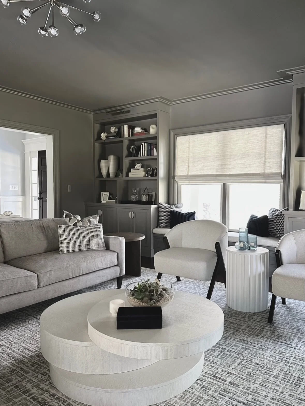 A major transformation for this now moody living room, complete with custom built-ins, decorative lighting and fun accents 🩶