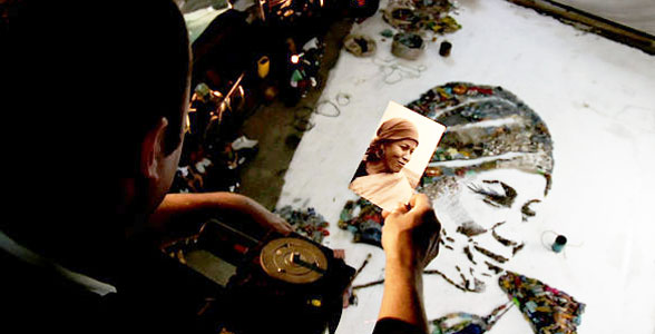 Muniz working on a trash portrait from a platform above