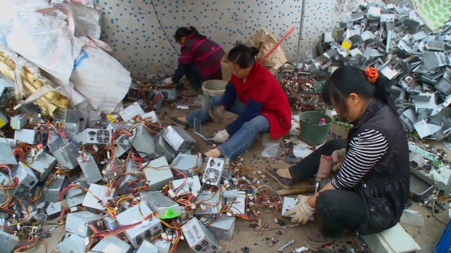 Women in Guiyu, China pick out precious metals from dumped e-waste