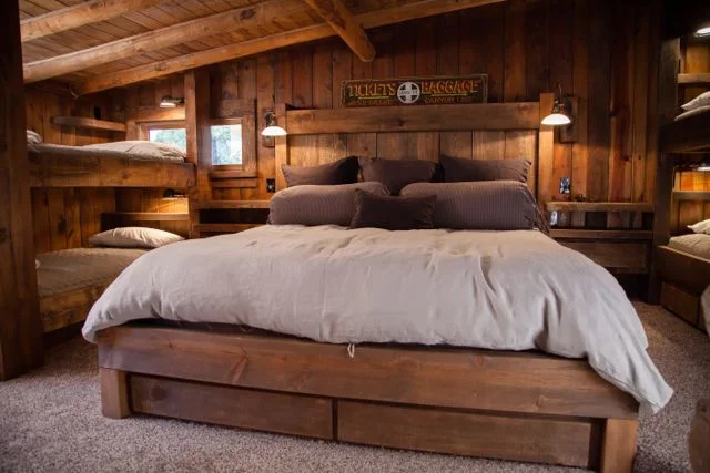 The Bunk Room. All the beds and doors were hand-crafted by our master carpenters. The custom queen size bed in the center has drawers underneath for storage. And floating built-in side tables to provide storage without crowding floor space. 