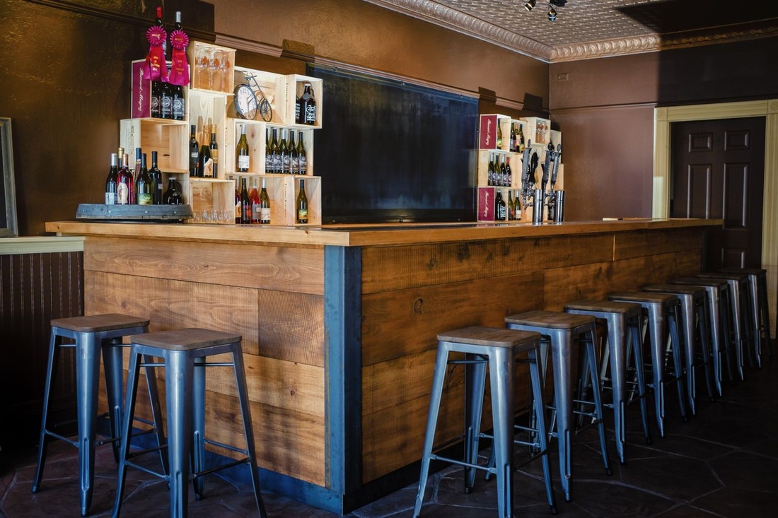 Custom bar with lots of wood to warm up the space and raw steel finishes.