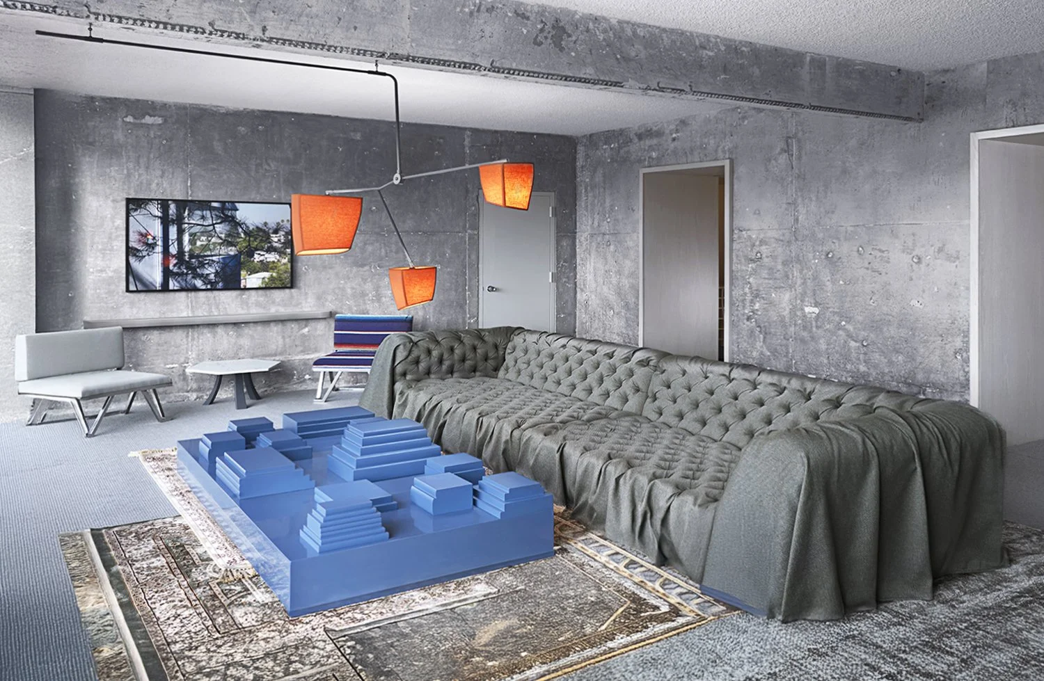 A hotel room at The Line Hotel with concrete walls features a tufted green sofa, a patterned rug, a unique blue geometric coffee table, and a wall-mounted TV. Red pendant lights hang from the ceiling, and there are two white chairs and a small table 