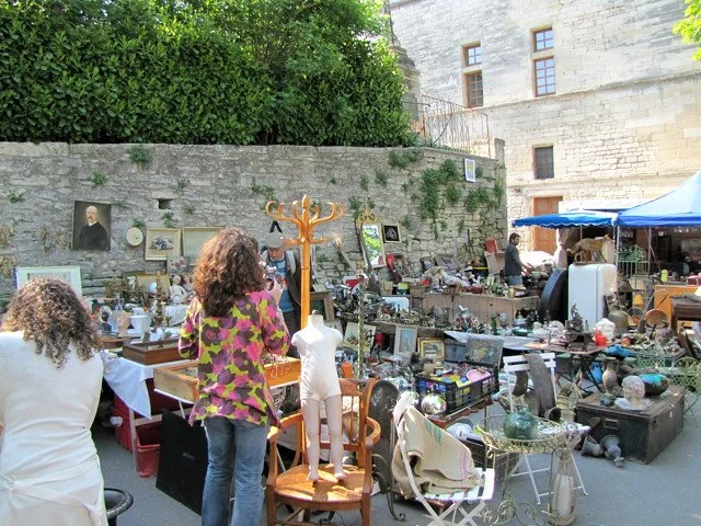 A flea market stall against a stone architectural backdrop