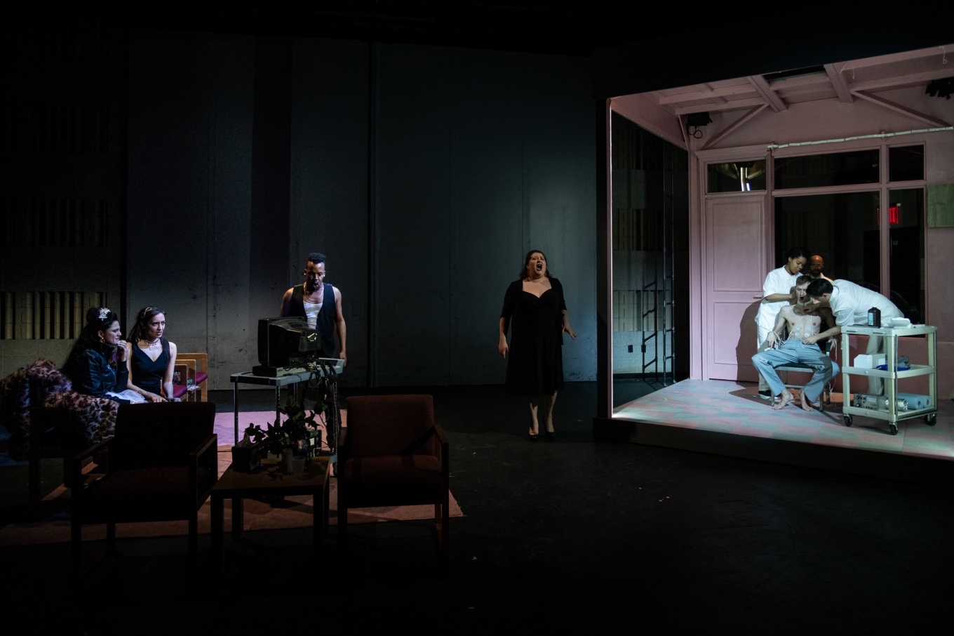 All watch in a nearby waiting room while Don Giovanni is "reprogrammed" to be a better member of society