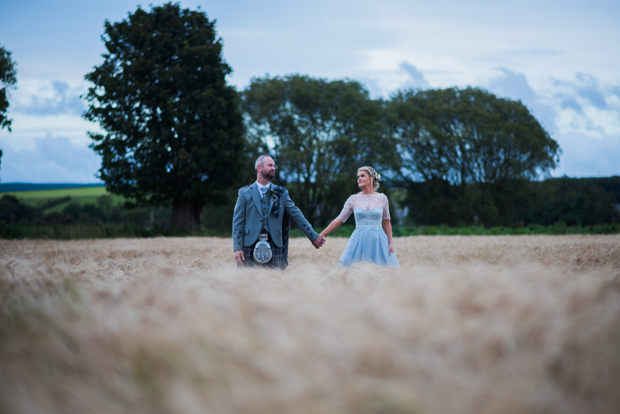 Bride and Groom standing in field at Dalduff Farm