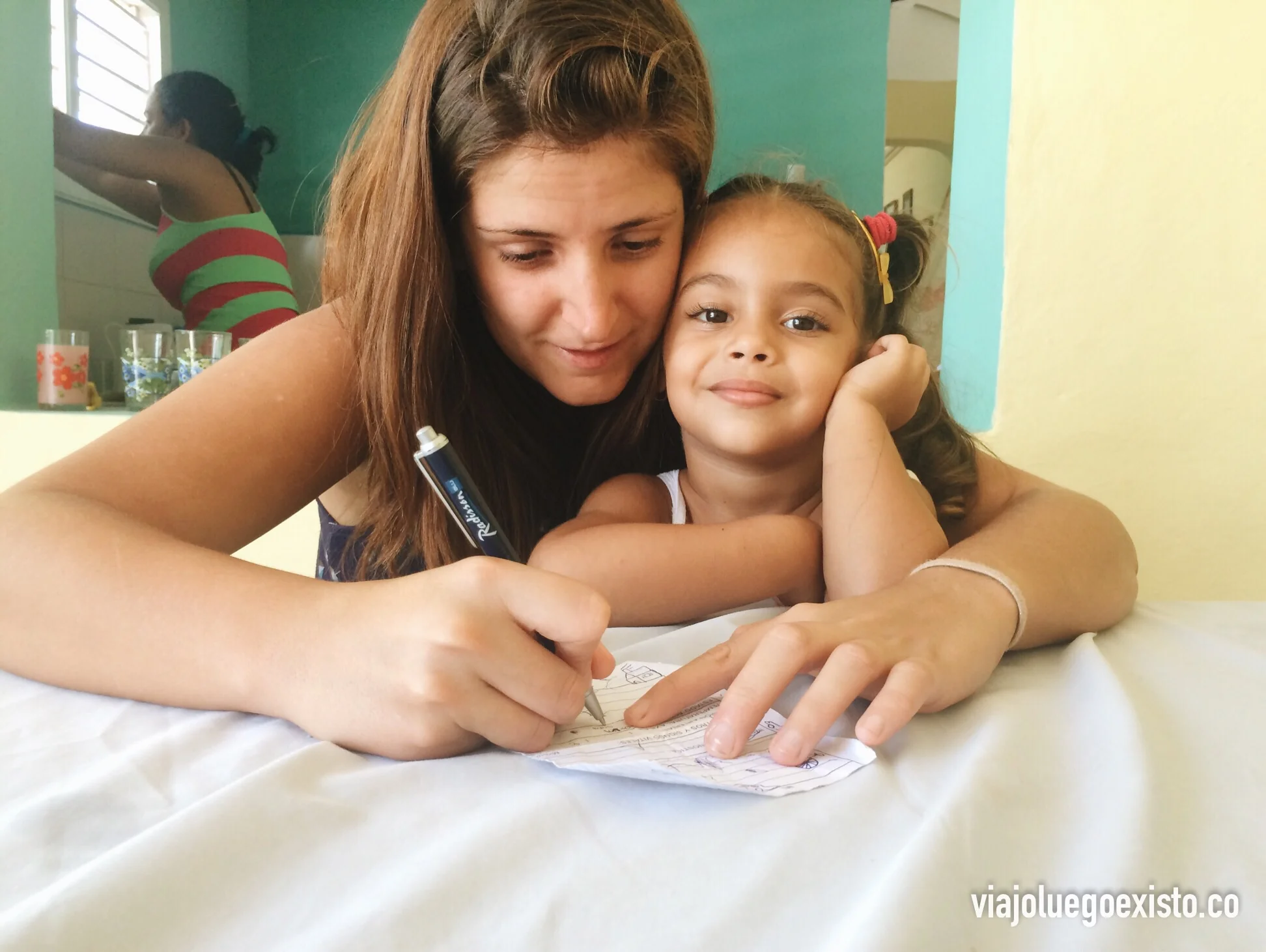 Tam ayudando a dibujar a Erika, una de las nietas de Alba.
