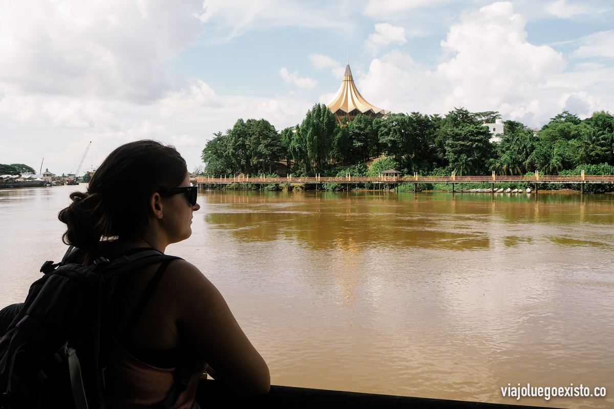 Tam admirando el río Sarawak, con la oficina del gobierno local de fondo