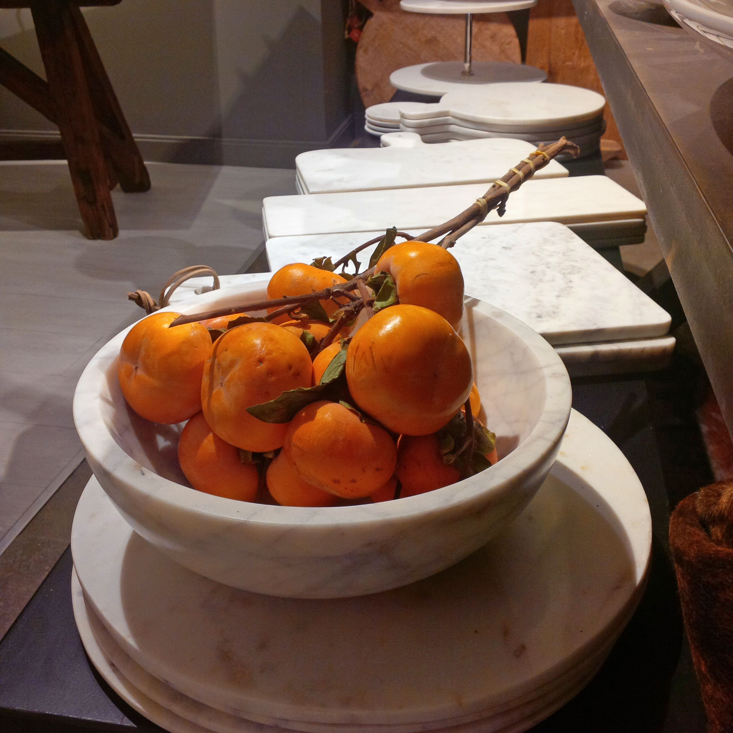 Marble platters with orange persimmons are a simple chic Holiday table setting.