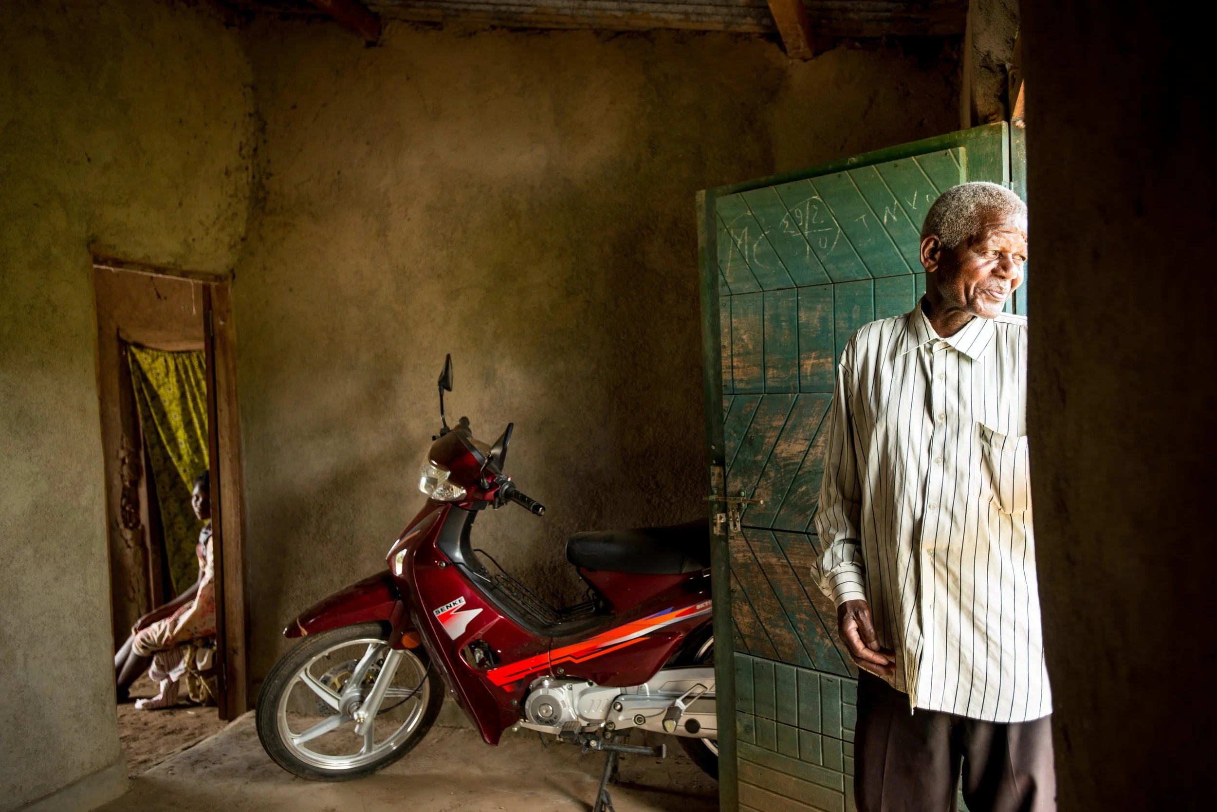 Ferdinand and his prized scooter he purchased with revenue generated from cacao farming, Kamango DRC. (2015)