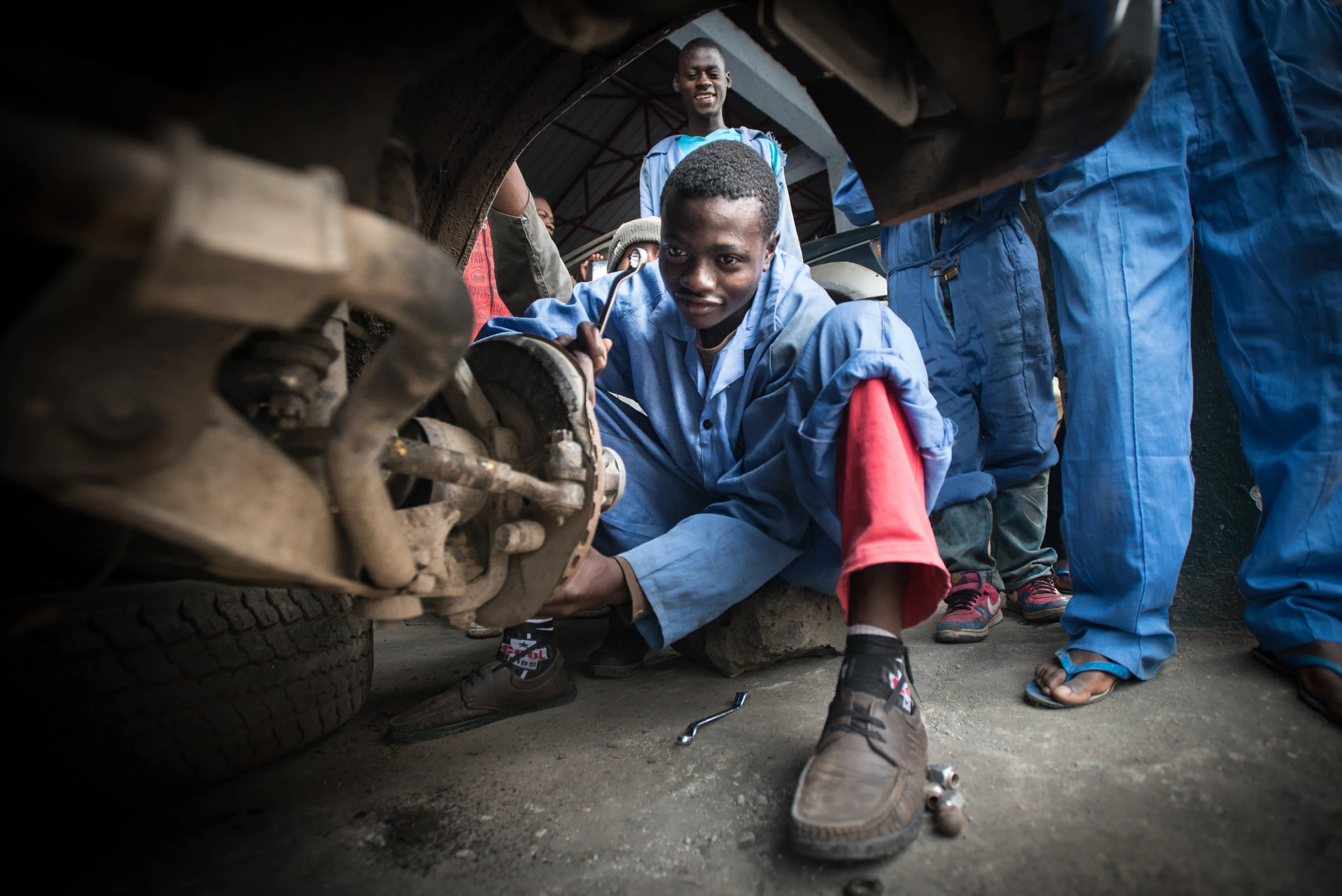 Students at ETN learn how to change a tire (Goma, DRC). 2014.