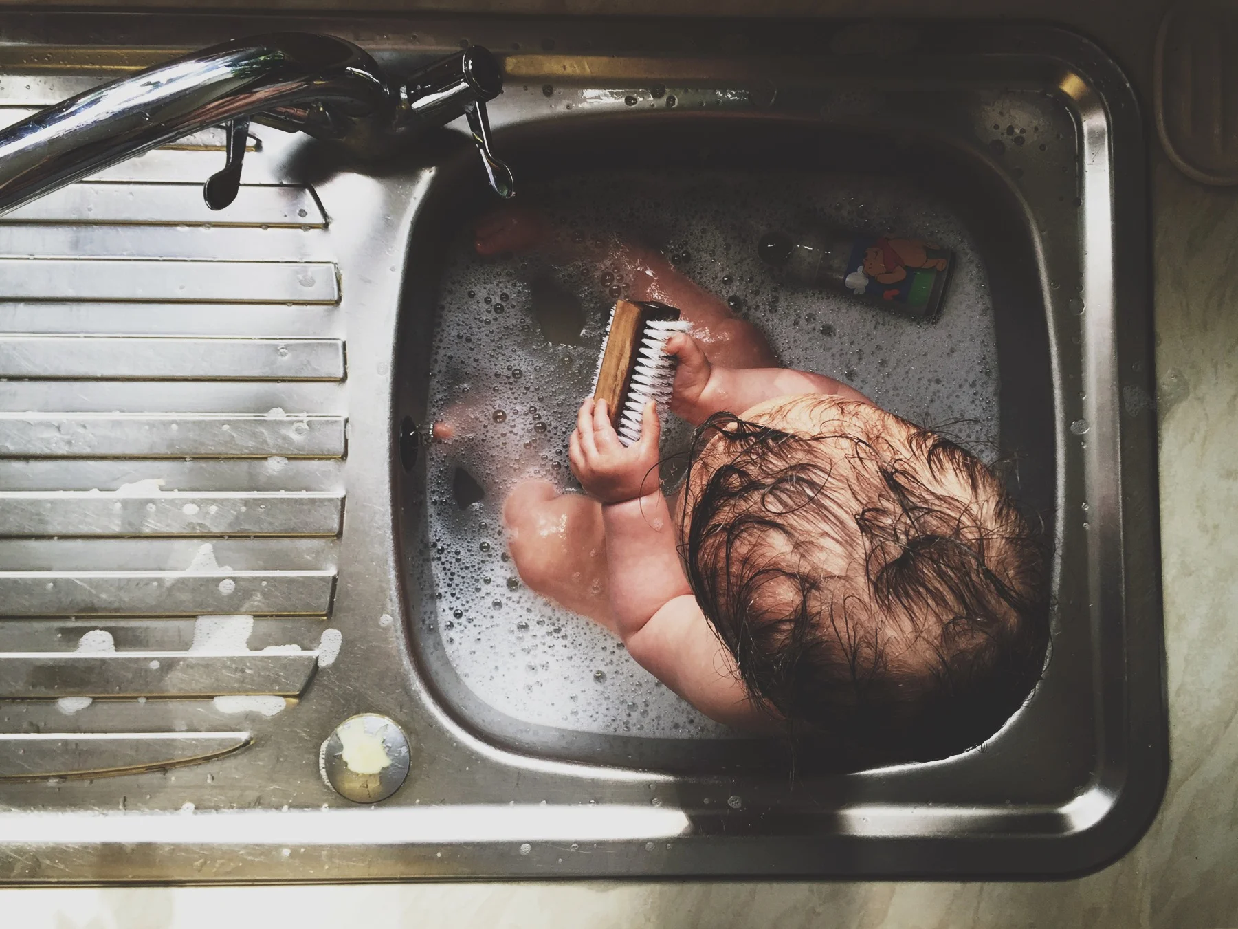 Shooting this photo of my daughter taking a bath in the sink from above created a more interesting photo, and allowed me to avoid including the clutter on the windowsill. 