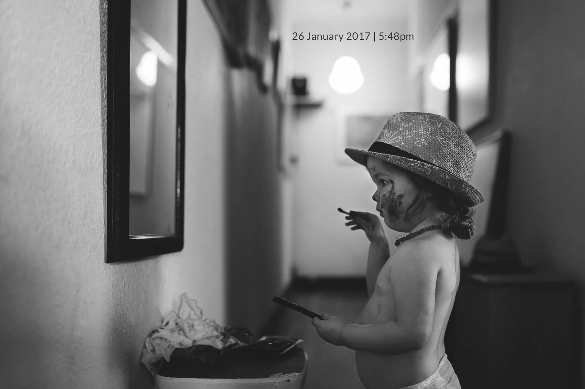 Melbourne family photography. Portrait of a young girl in a hat looking at herself in the mirror.