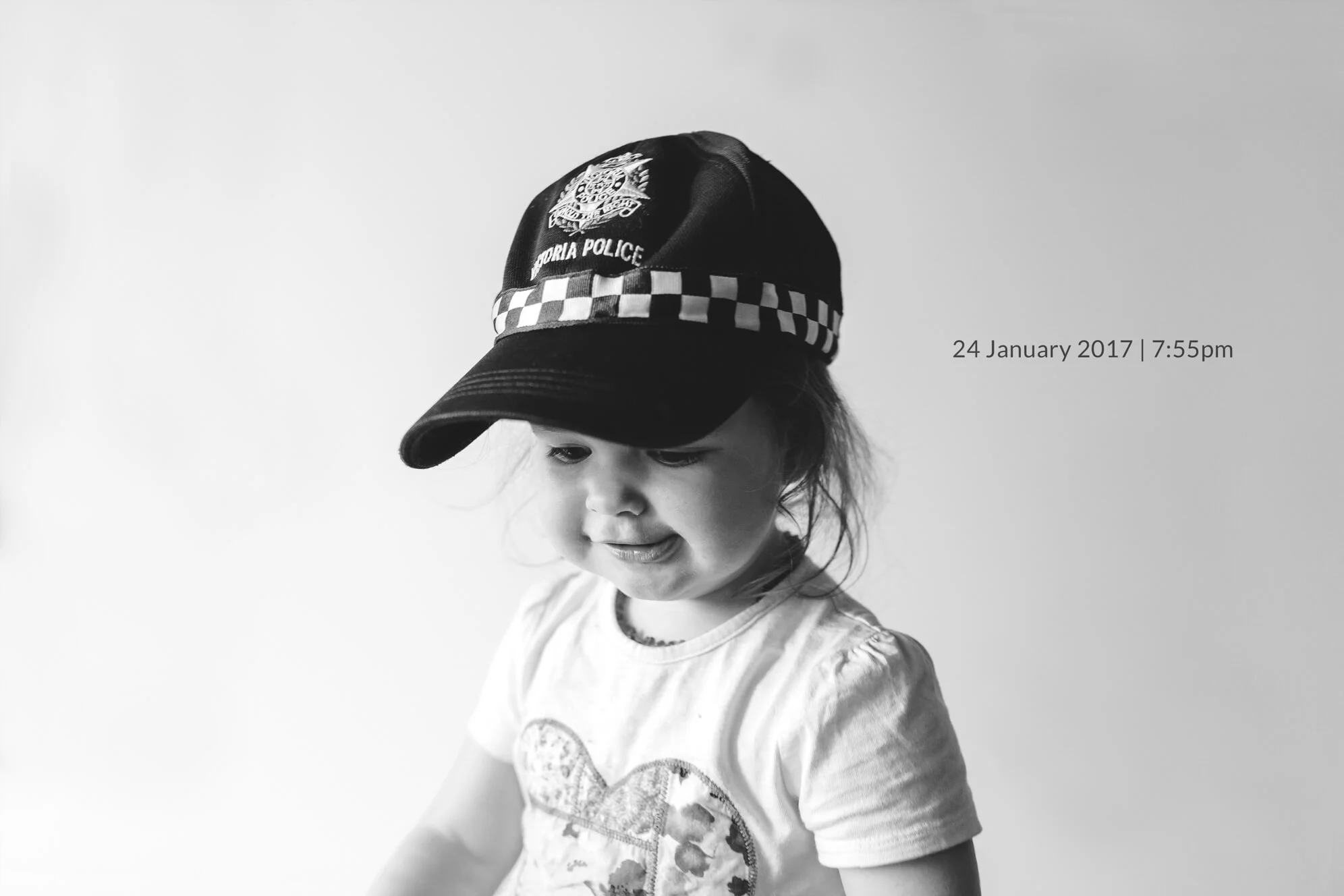 Family lifestyle photography in Melbourne. Portrait of a toddler wearing a police cap.