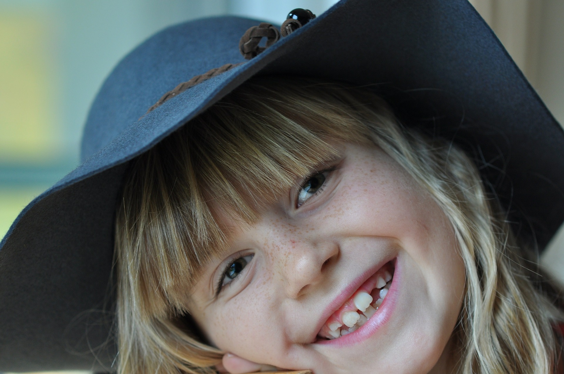 Laughing girl with a blue hat.