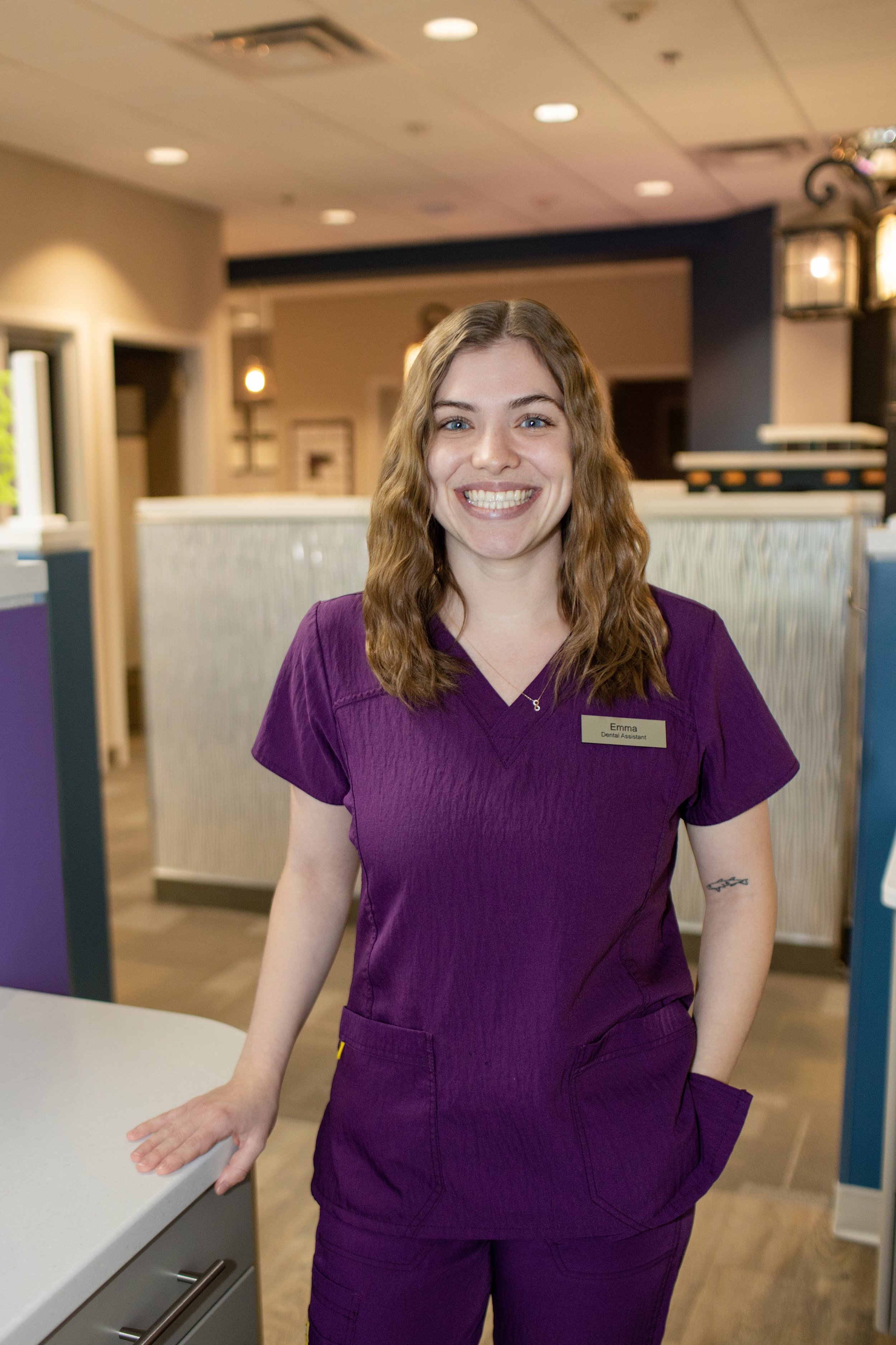 Photo of Emma, a dental assistant in purple scrubs
