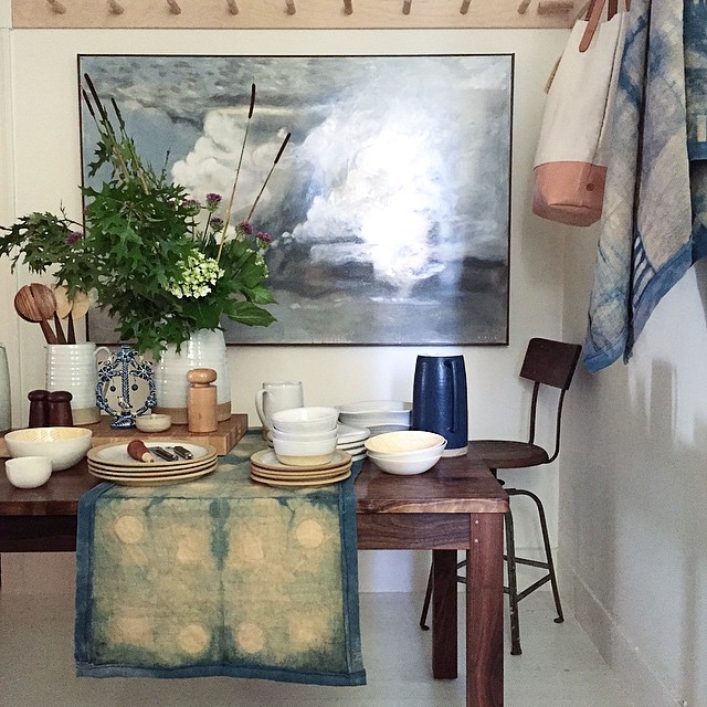 Table Runner (on table) - Fennel over-dyed with Indigo on Linen Table Runner (hung on right) - Fennel over-dyed with Indigo on Linen Tote (hung on right) - Canvas and Leather Styled at The Perish Trust