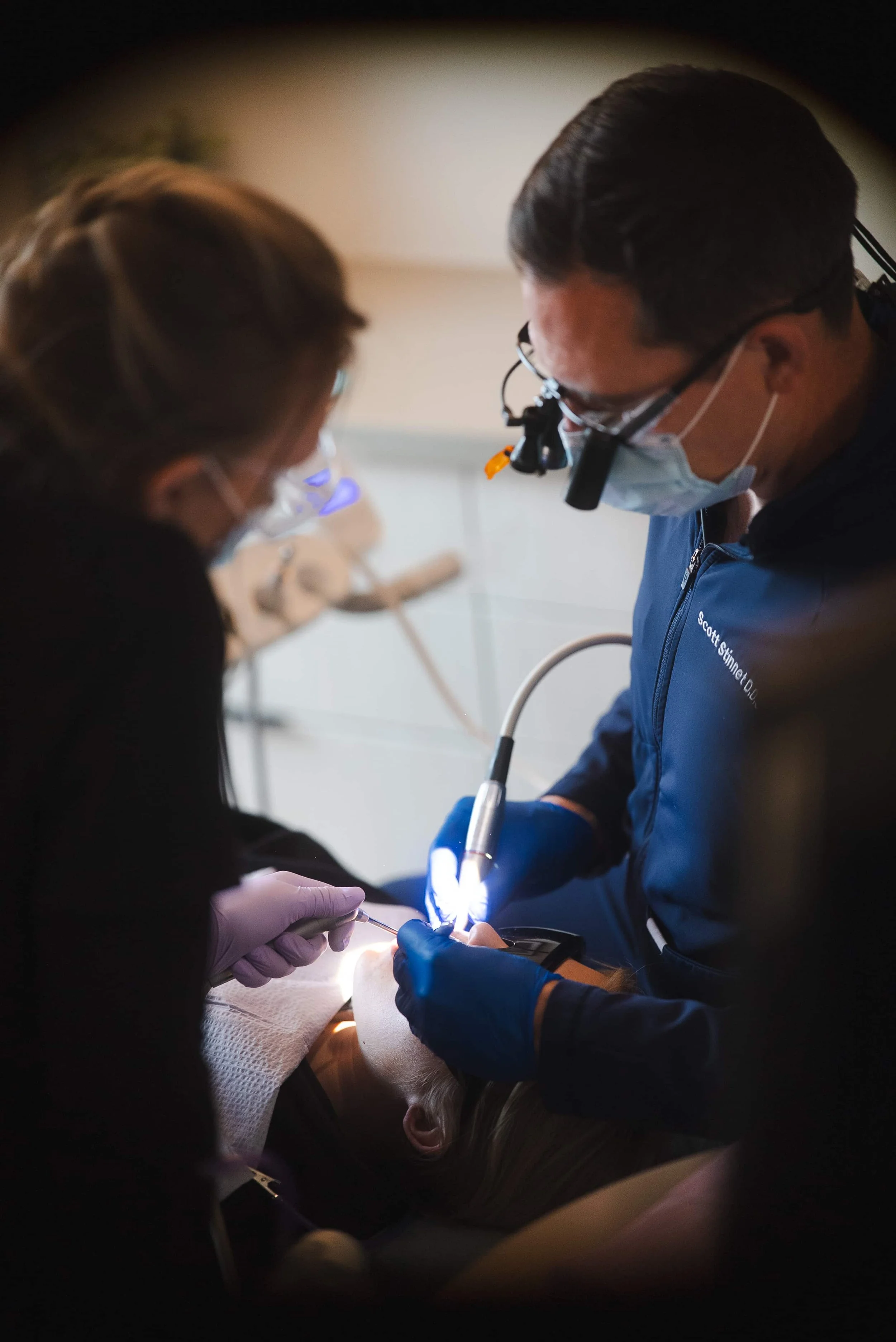 Dentists and dental assistants performing a dental procedure on a patient in a dental clinic.